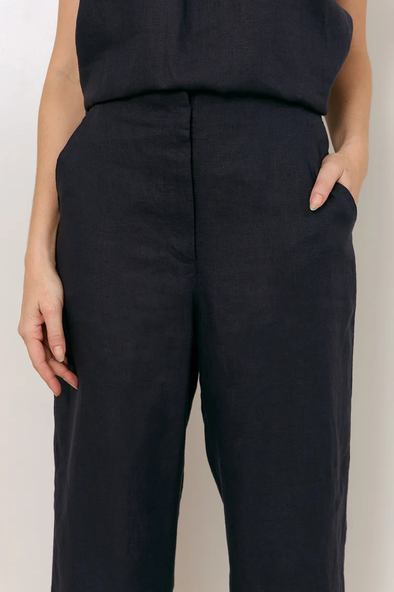 Image of Close-up of a woman wearing Adorne  dark navy wide-leg trousers with a front crease and side pockets, paired with a matching dark sleeveless top against a plain light background.