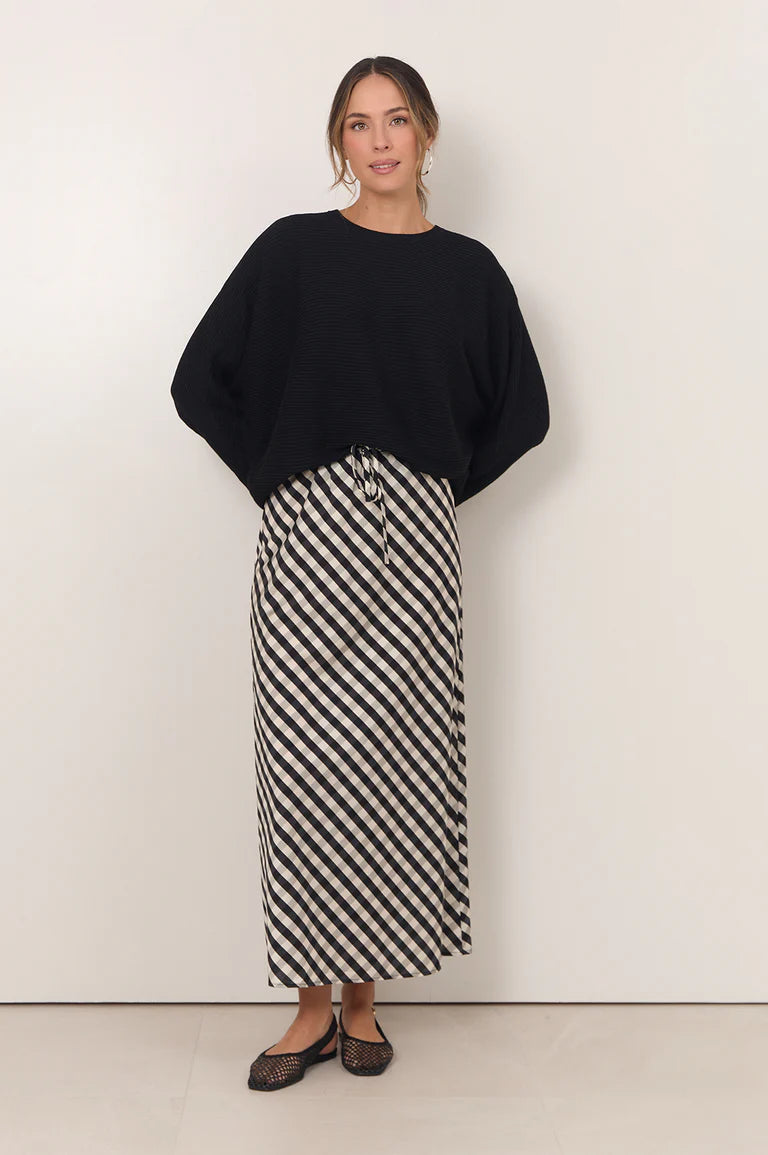 Image of Woman wearing Adorne gingham maxi shirt paired with a black jumper on a plain background 