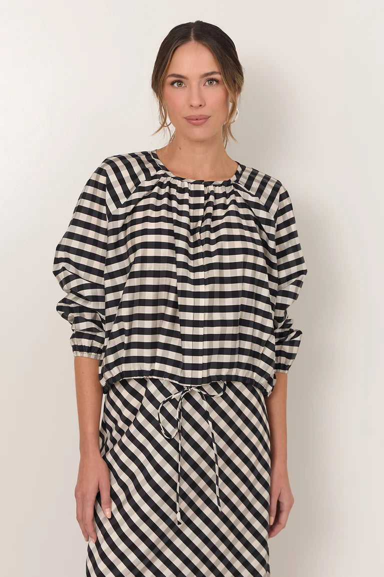 Image of Woman wearing a Adorne black and white striped dress against a plain bbackground