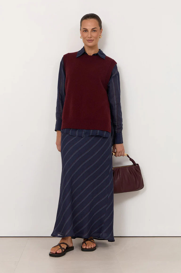 Image of Woman wearing a Adorne burgundy sweater and blue skirt with a white background
