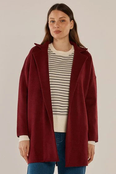 Image of Woman wearing a Betty Basics red coat over a striped shirt with a plain background
