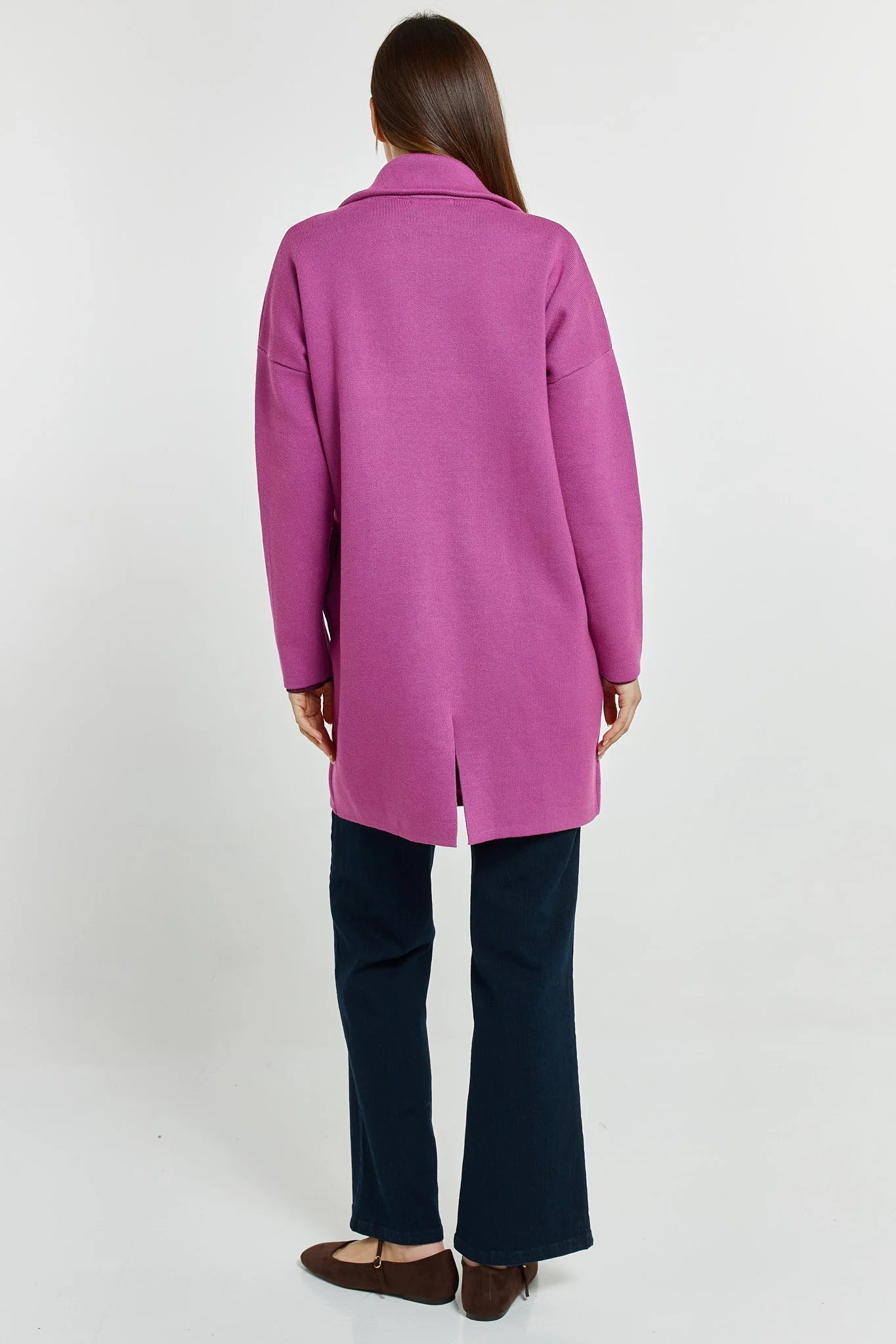 Woman wearing a Betty Basics pink coat on a white background