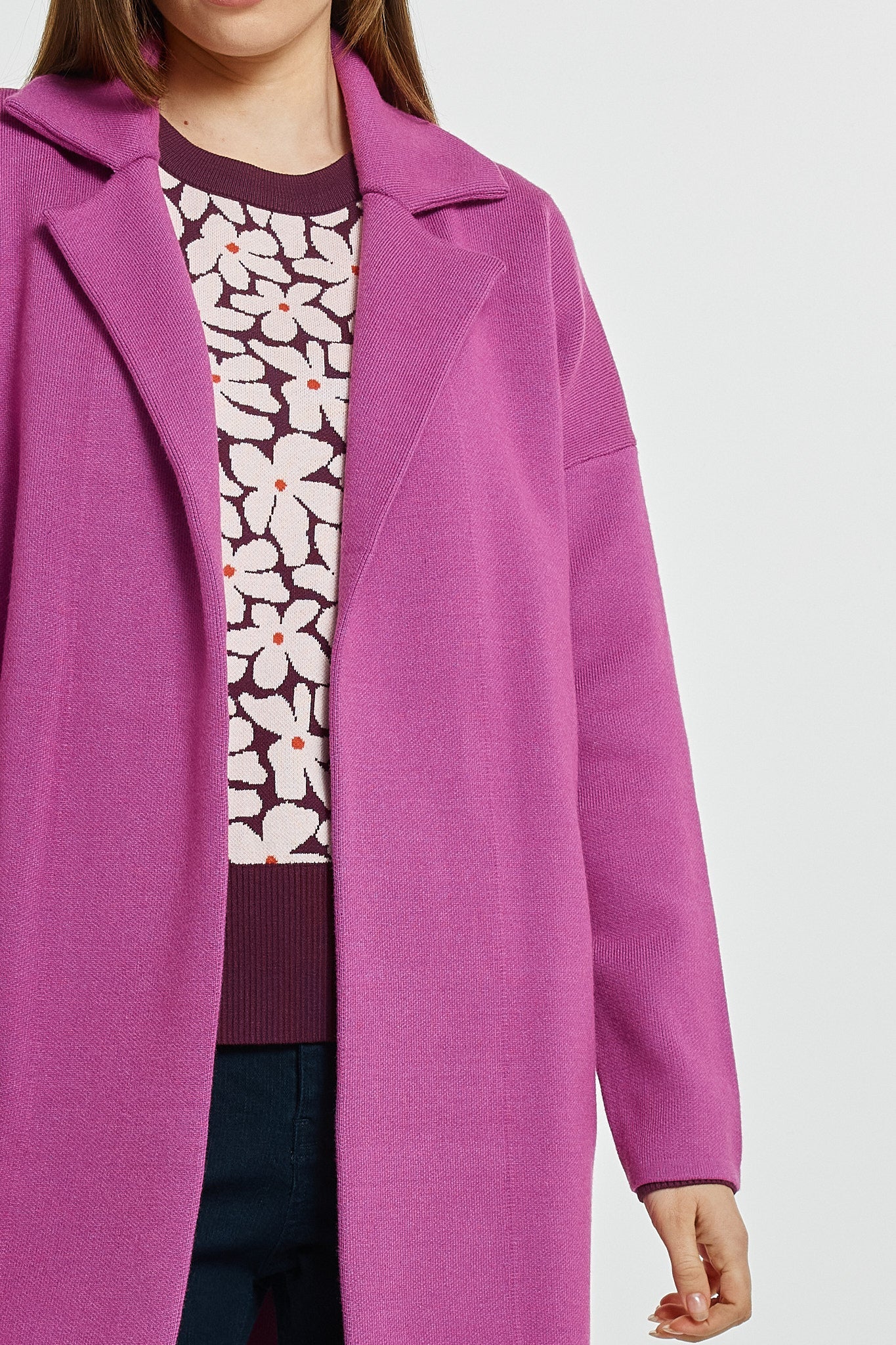 Image of Woman wearing a Betty Basics purple coat over a floral shirt on a white background