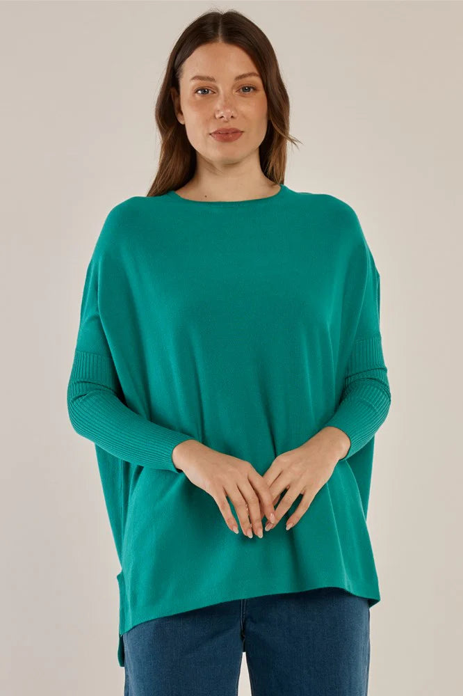 Image of Woman wearing a Betty Basics teal sweater against a plain background