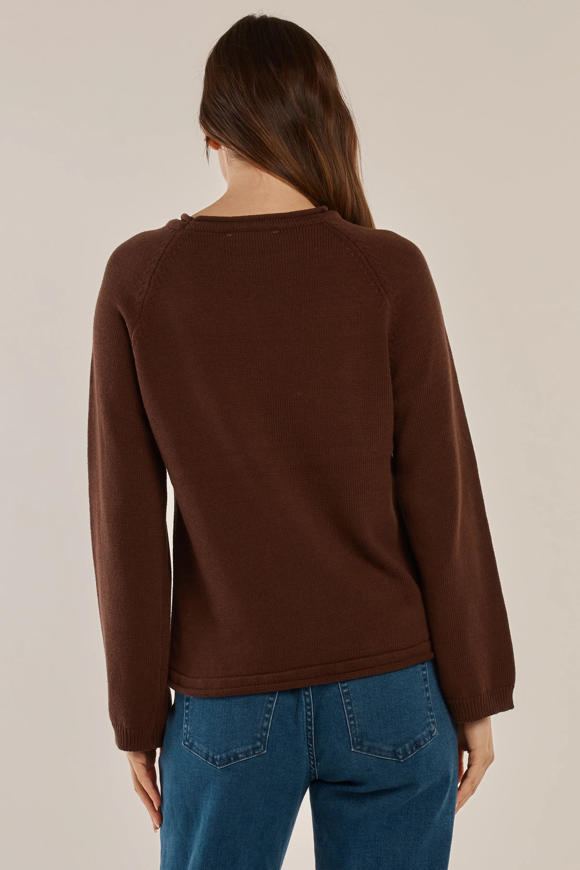 Image of Woman wearing a Betty Basics brown sweater and blue jeans on a beige background