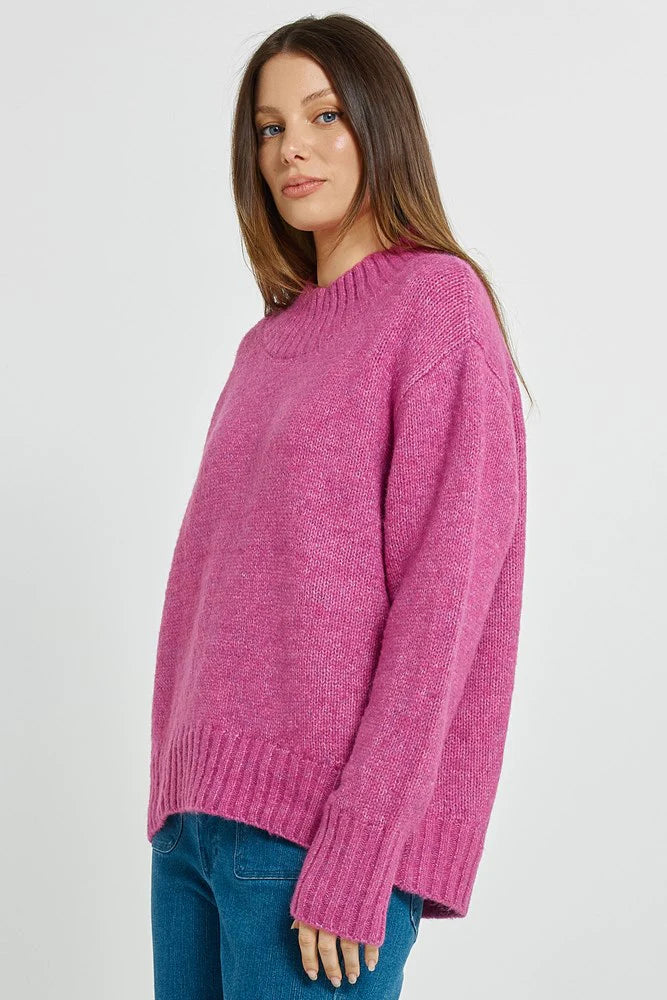 Woman wearing a Betty Basics pink sweater on a white background