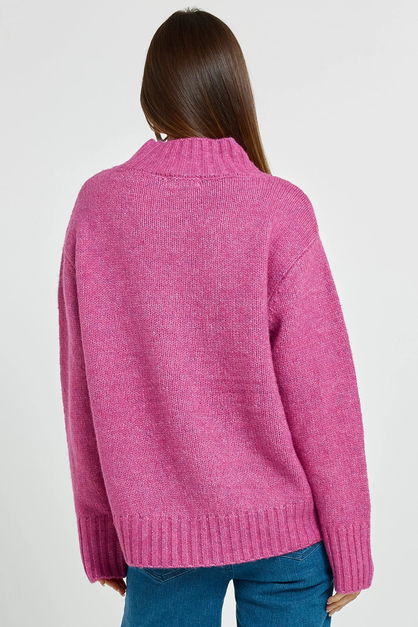 Person wearing a Betty Basics pink knitted sweater on a white background