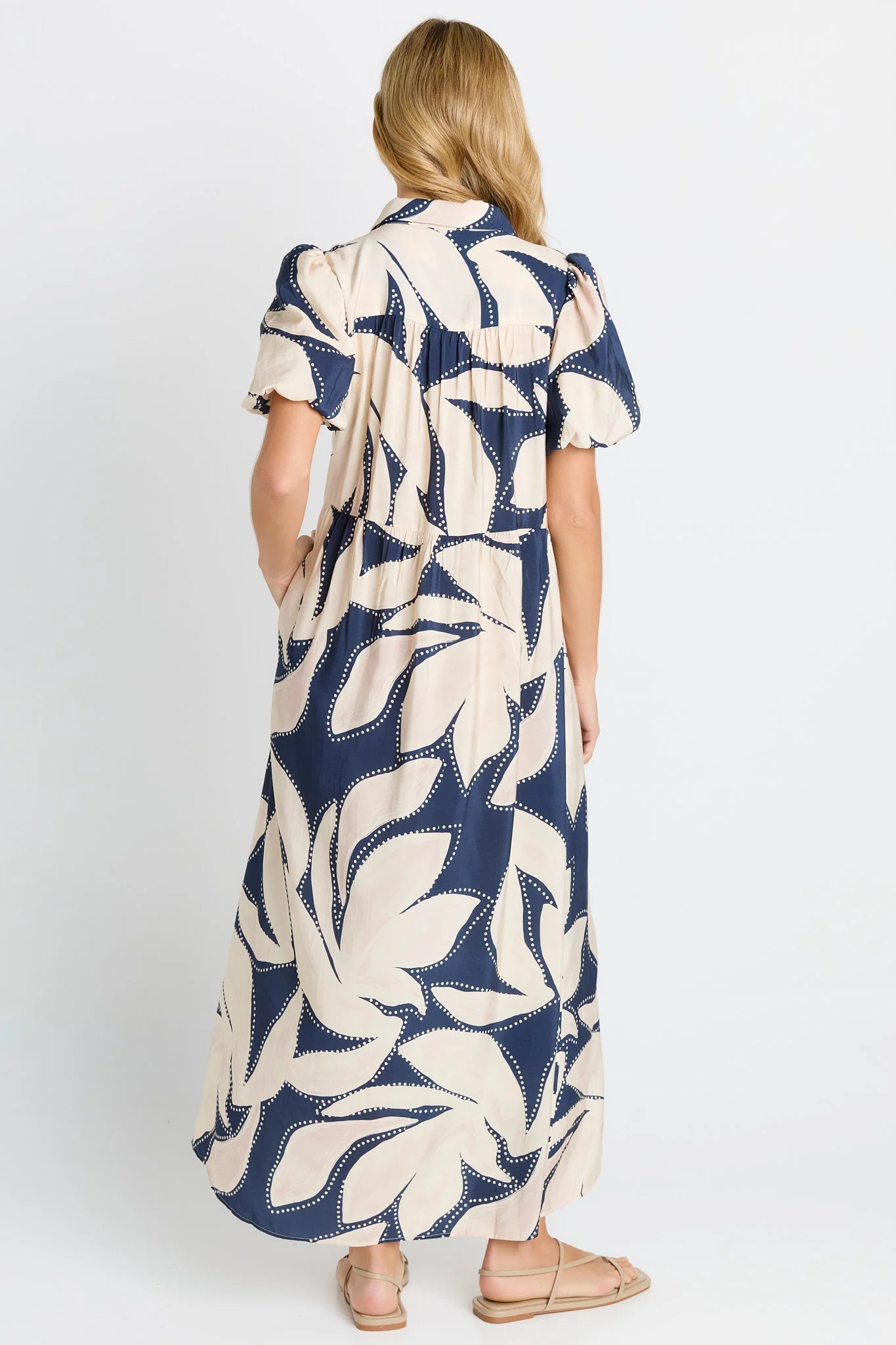 Image of Woman wearing a Betty Basics long dress with a blue and white pattern on a white background