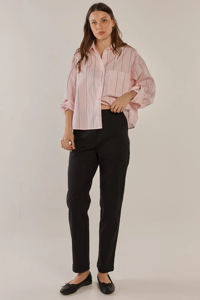 Image of Woman wearing a pink striped shirt and Betty Basics black pants on a plain background