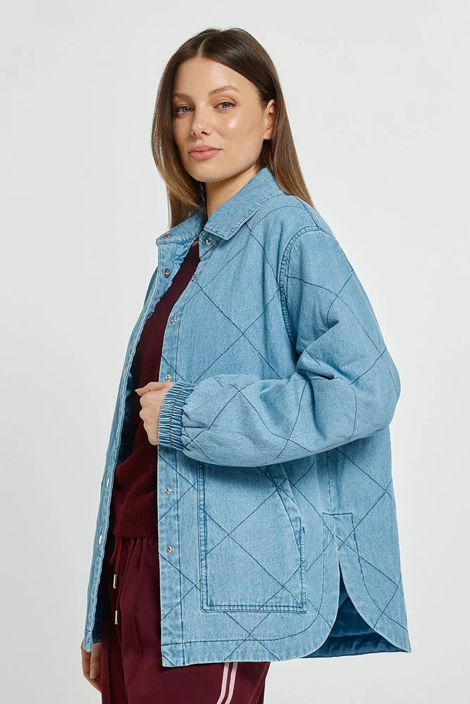 Woman wearing a Betty Basics blue denim jacket on a white background