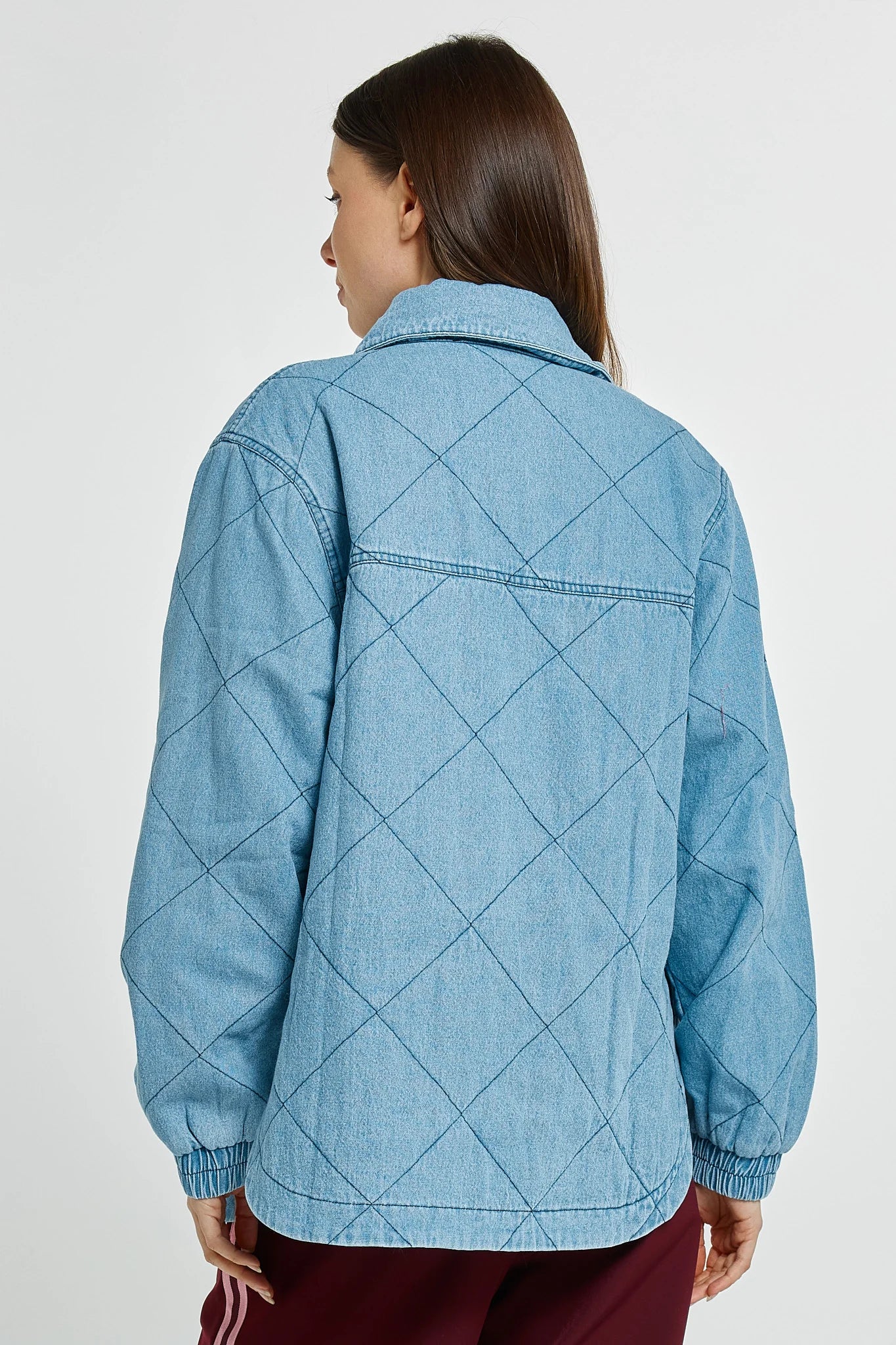 Image of Woman wearing a Betty Basics blue quilted jacket on a plain background