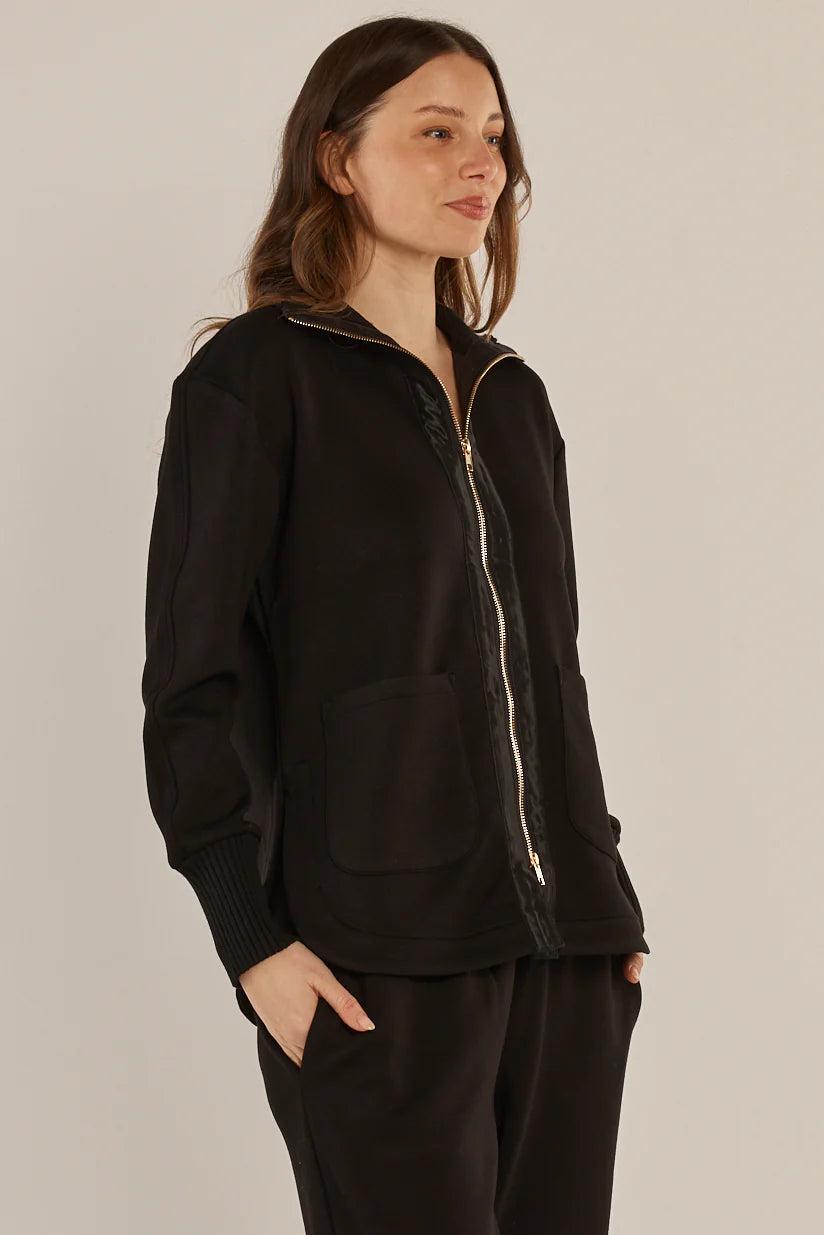 Image of Woman wearing a Betty Basics black zip-up jacket and pants on a plain background
