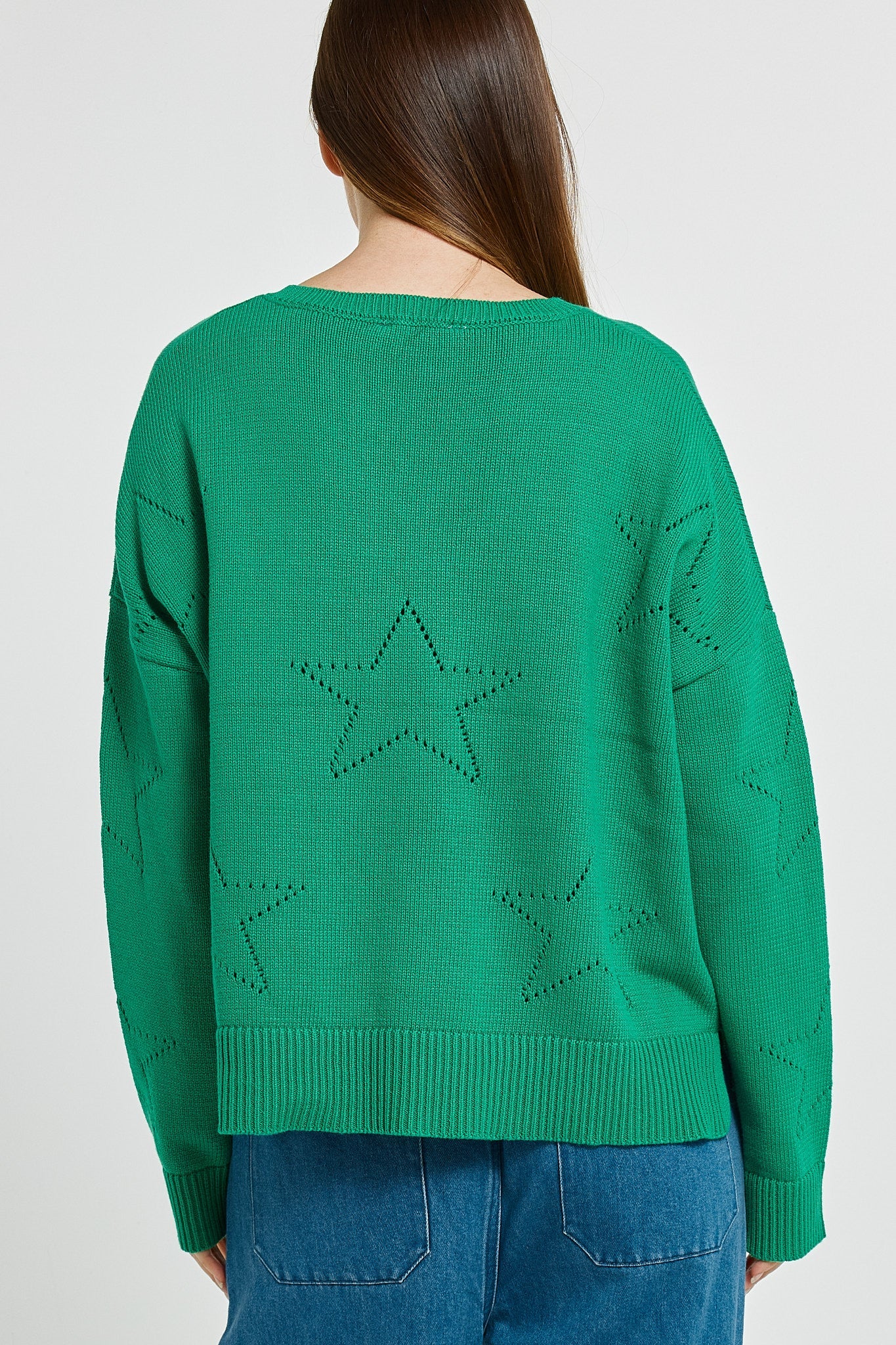 Image of Betty Basics green sweater with star designs worn by a woman on a white background
