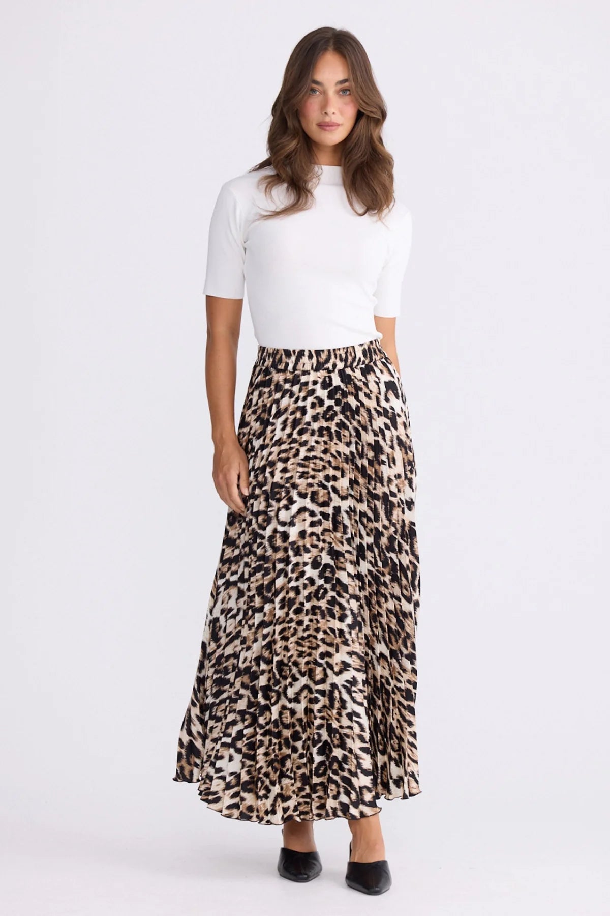 Image of Woman wearing a white top and Brave and True leopard print skirt on a white background