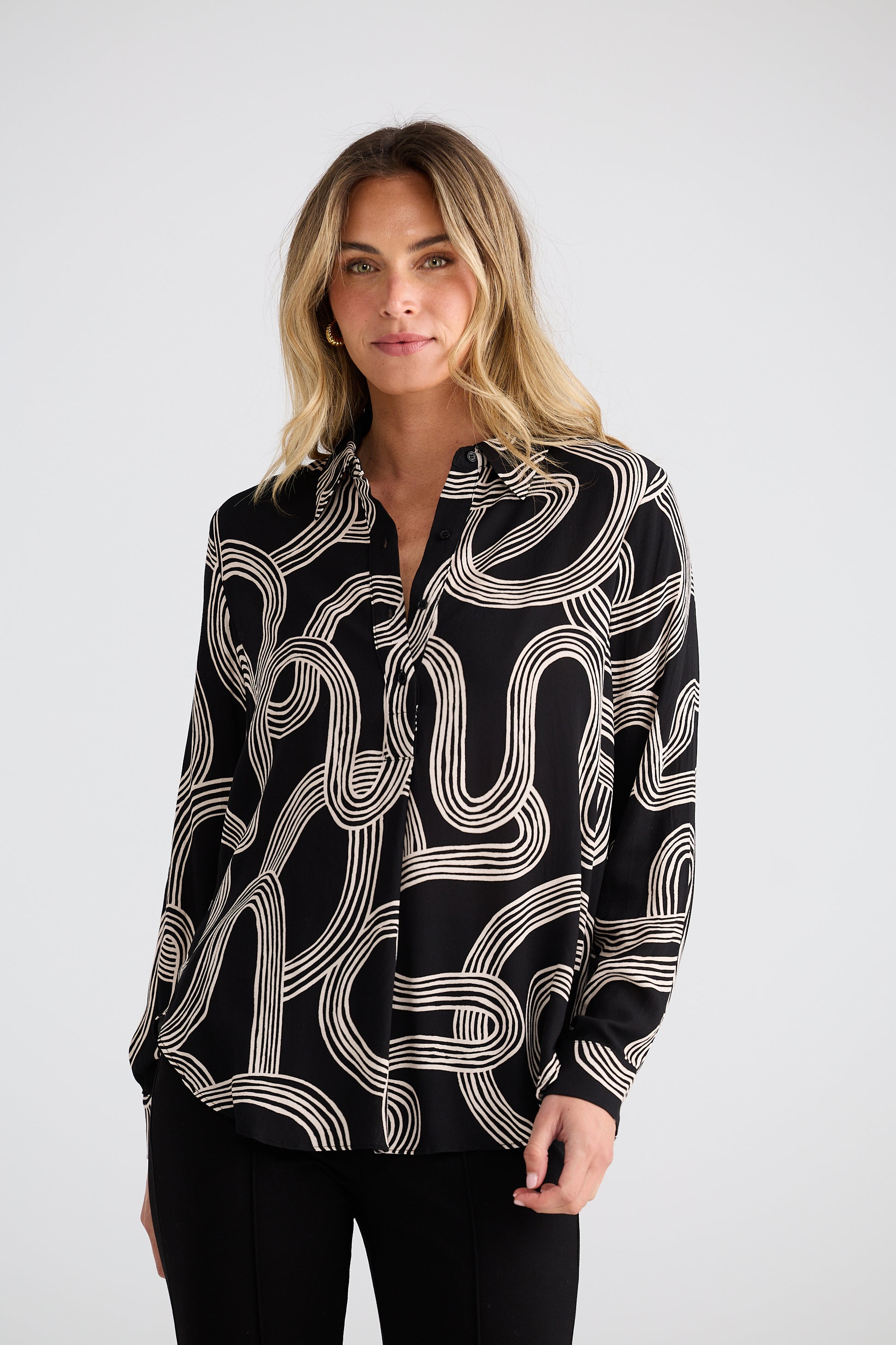 Woman wearing a Brave and True black patterned shirt against a white background