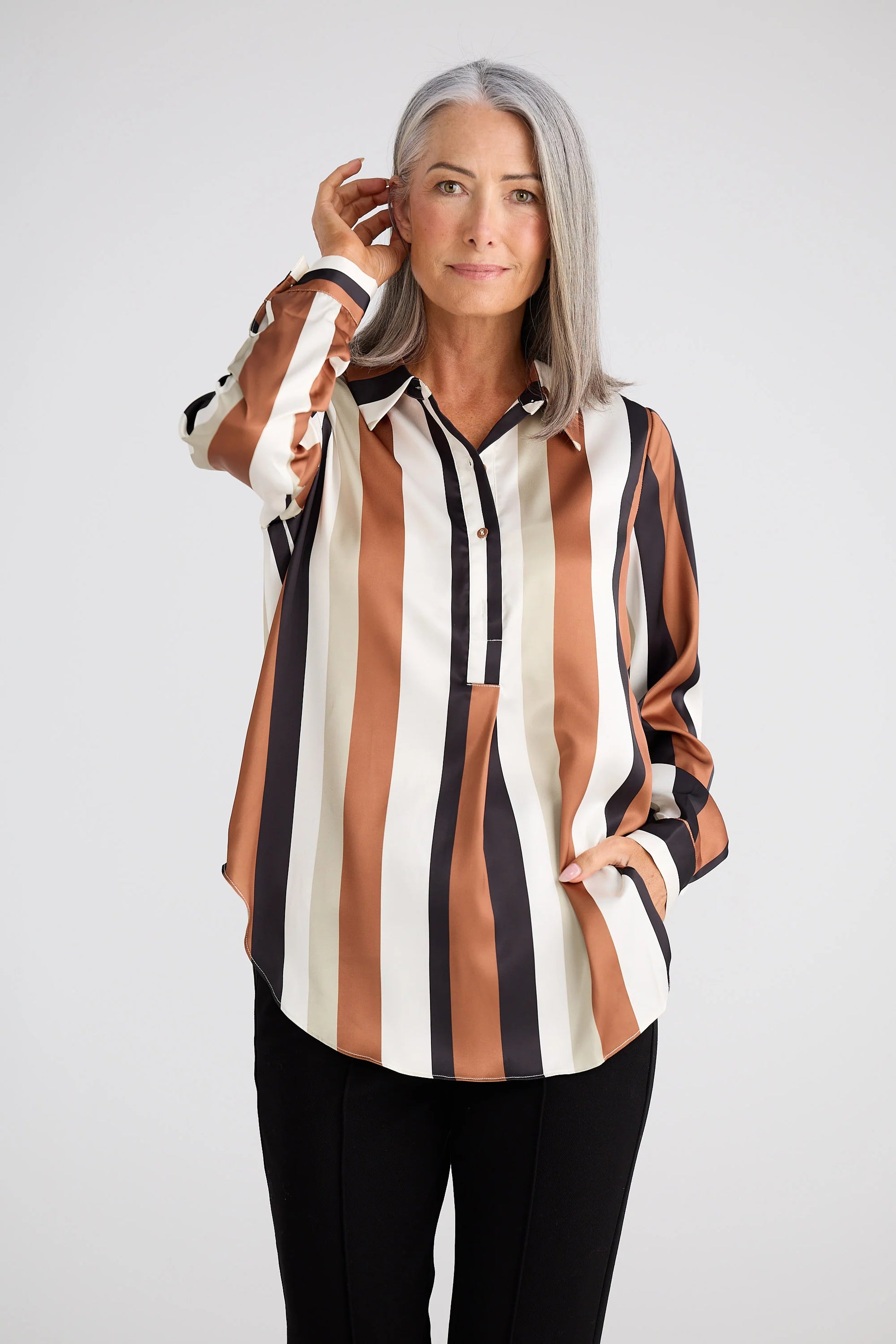 Woman wearing a Brave and True striped shirt with a white background