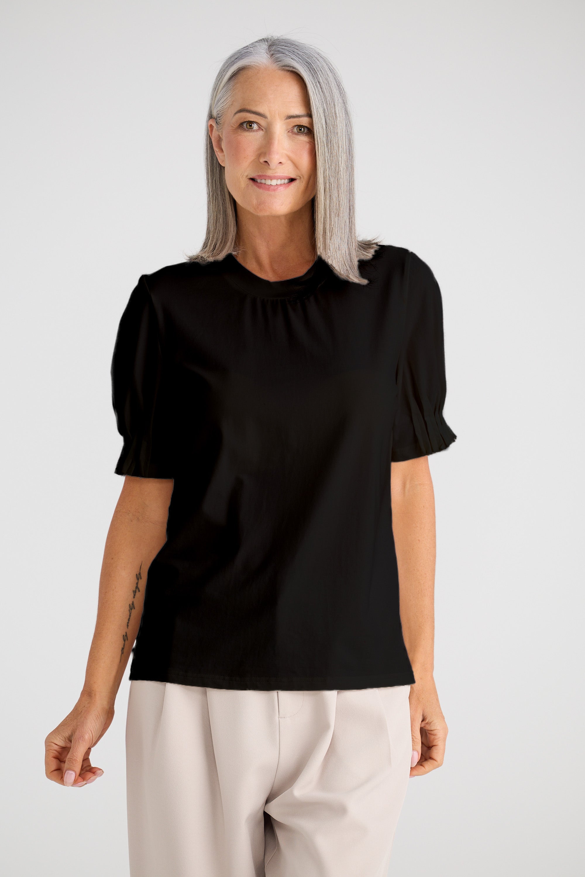 Collection of Woman wearing a Brave and True black blouse with puff sleeves on a white background in a gallery layout