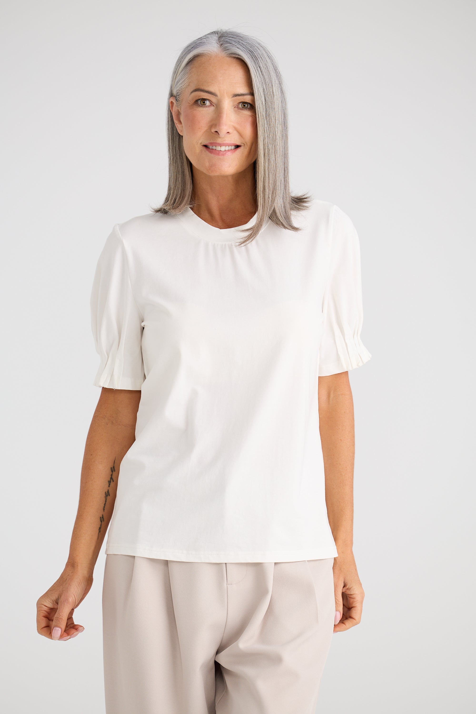 Collection of Woman wearing a Brave and True white blouse with puff sleeves against a plain background in a gallery layout