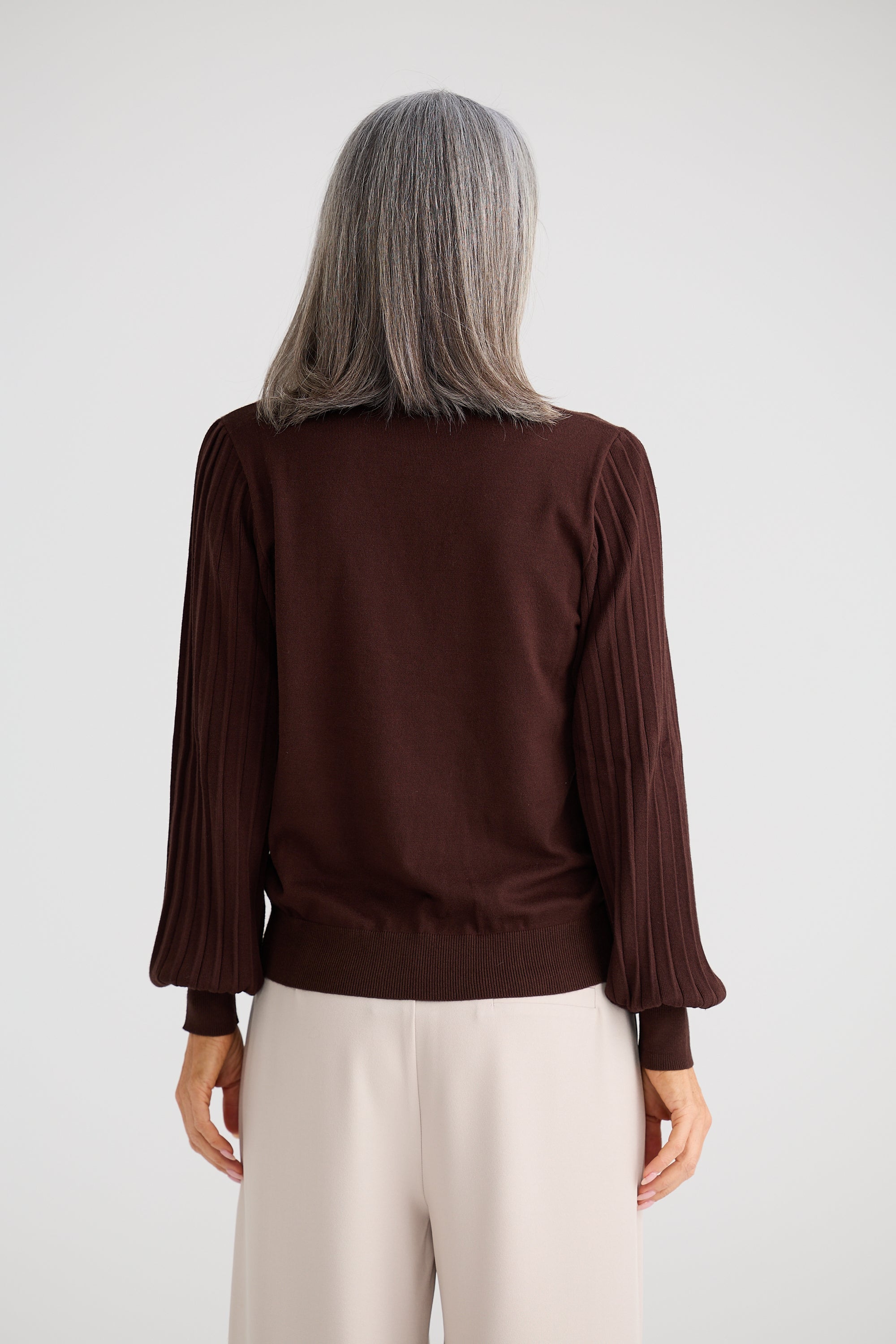 Image of Woman wearing a Brave & True brown blouse with long sleeves on a white background