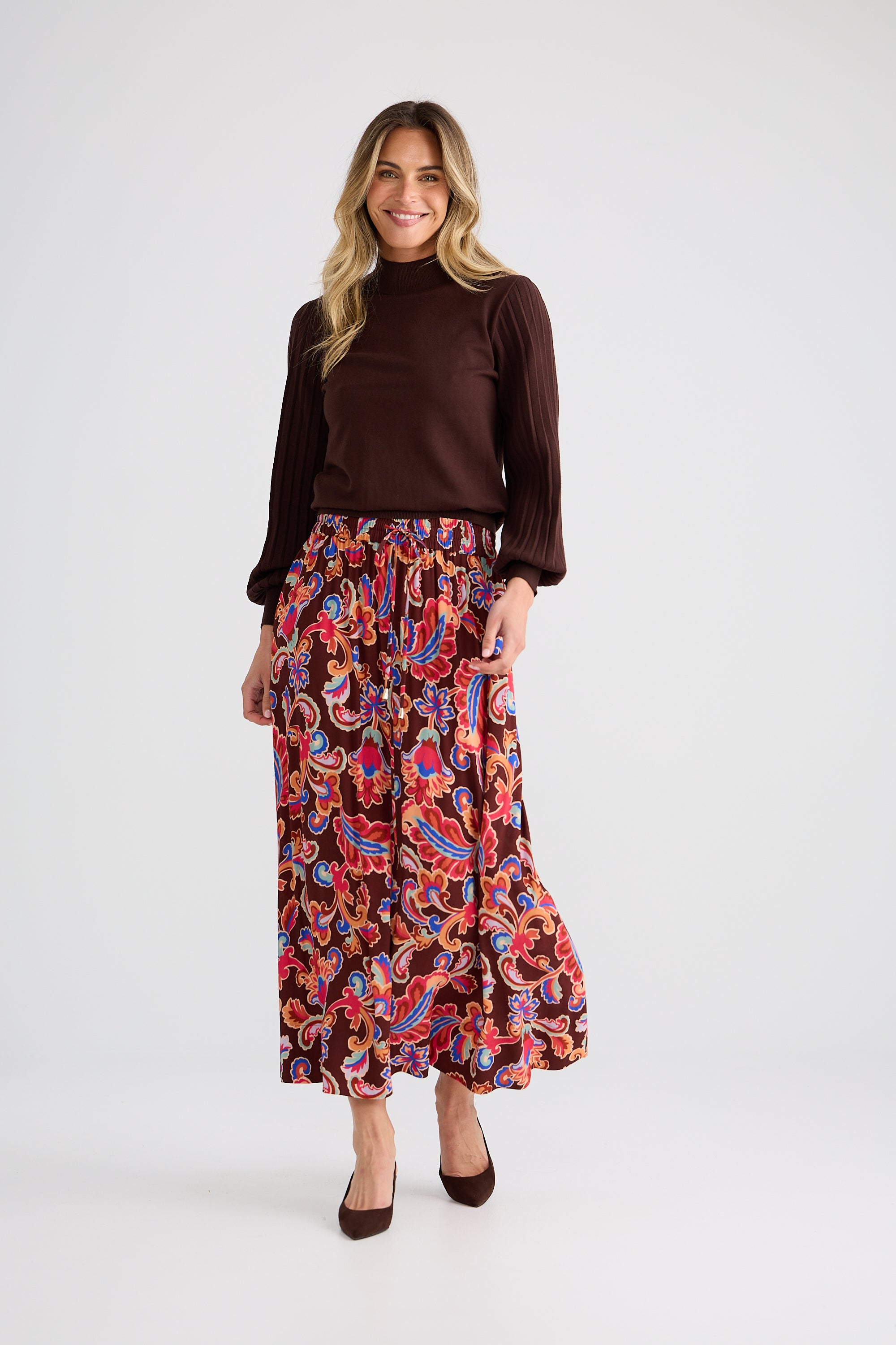 Collection of Woman wearing a brown top and Brave and True colorful patterned skirt on a white background in a gallery layout