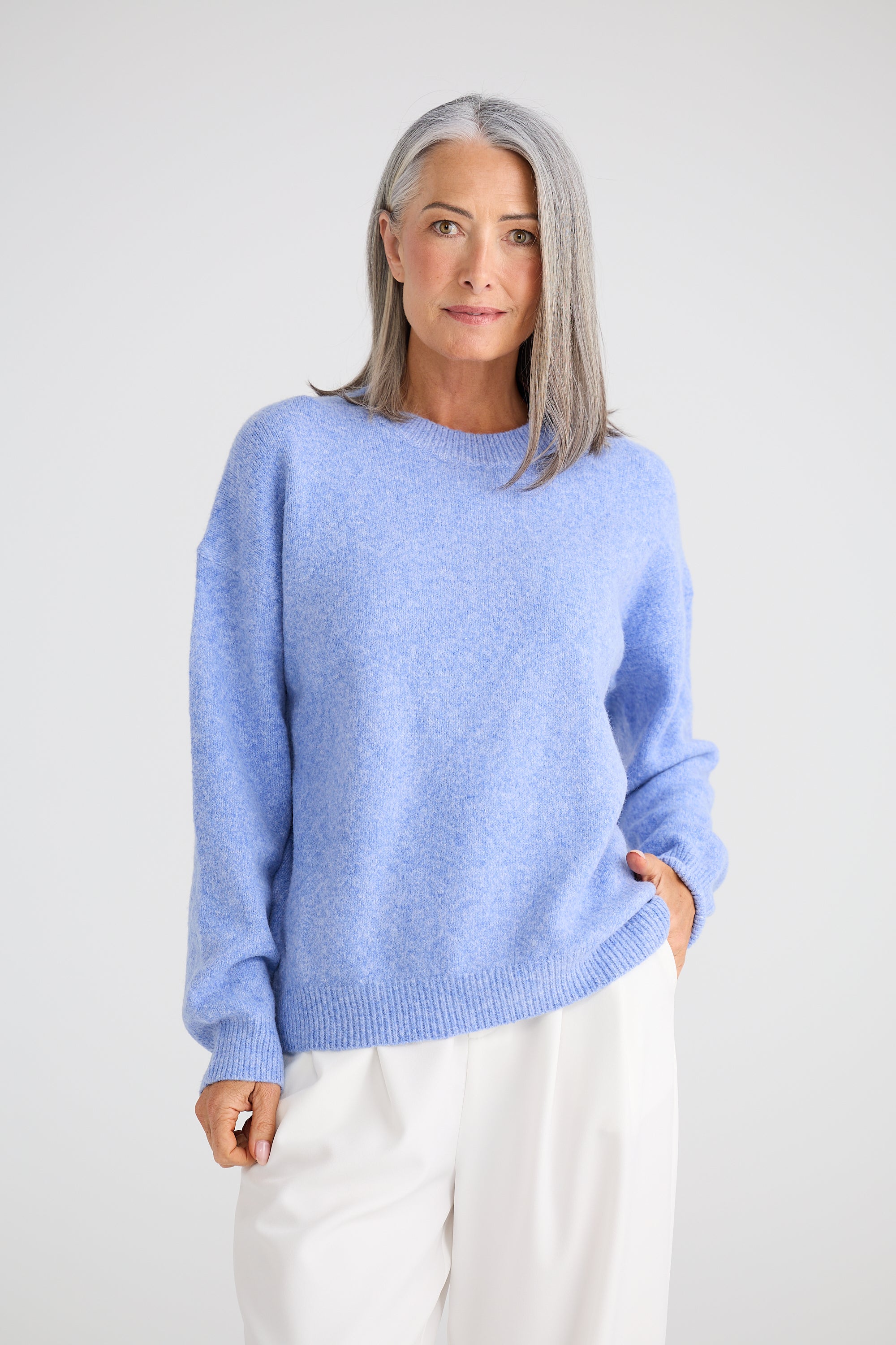 Image of Woman wearing a Brave and True light blue sweater against a white background