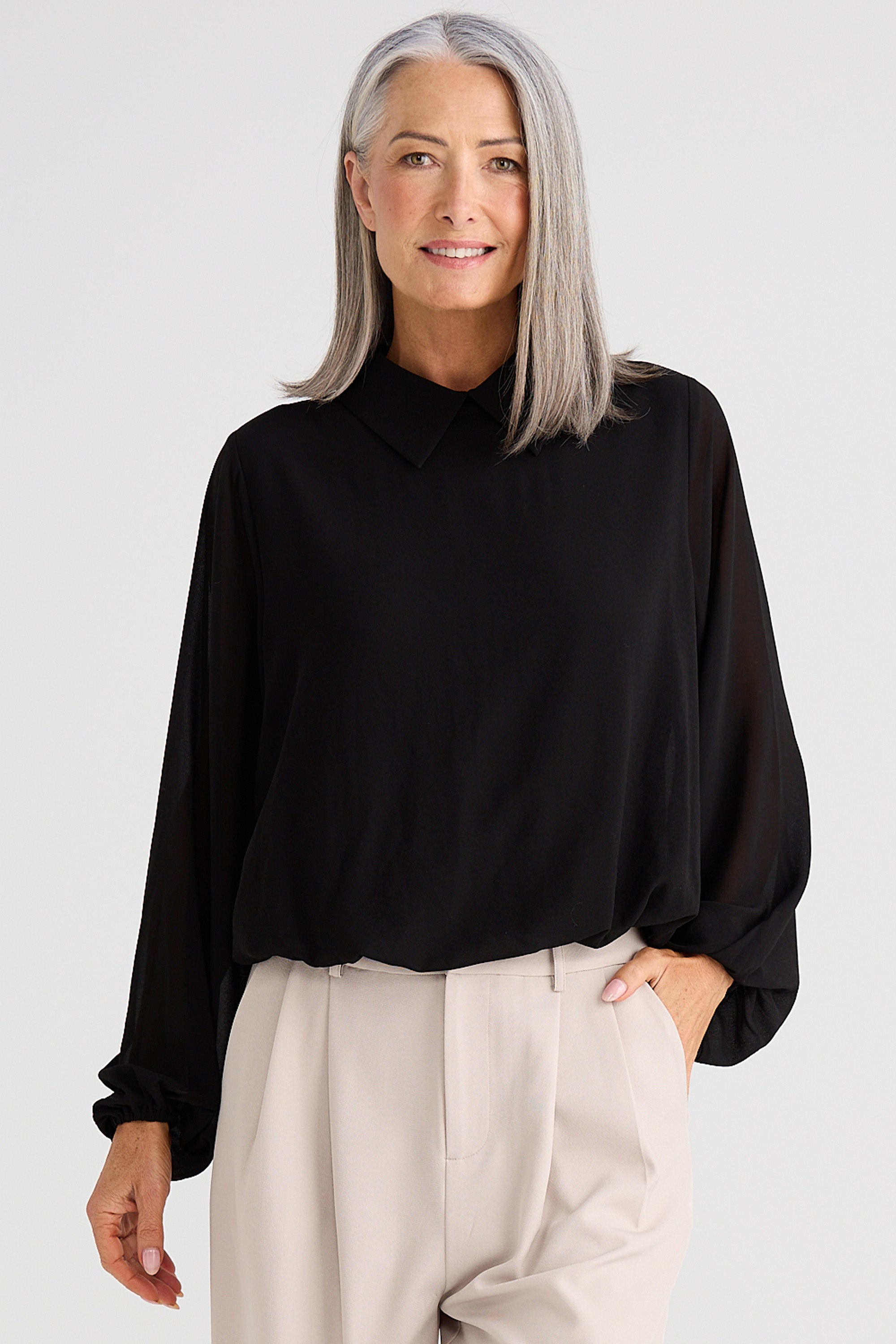 Collection of Woman wearing a Brave and True black blouse and beige pants against a white background in a gallery layout