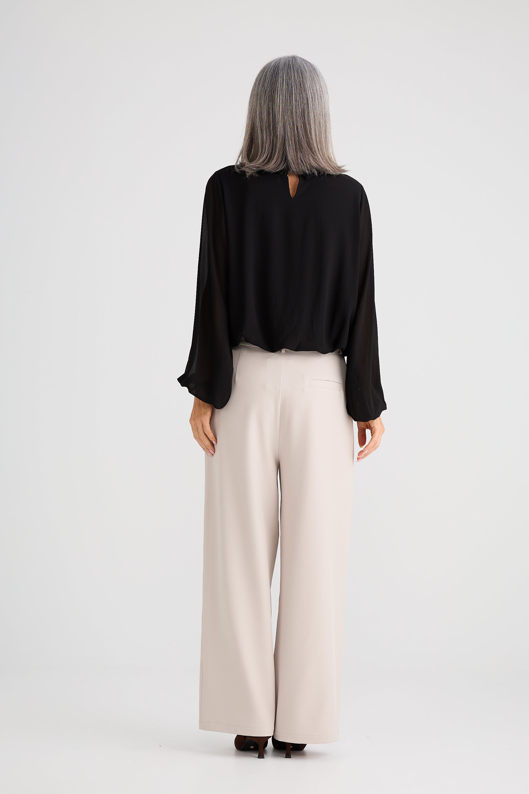 Collection of Woman wearing a Brave and True black top and beige pants on a white background in a gallery layout