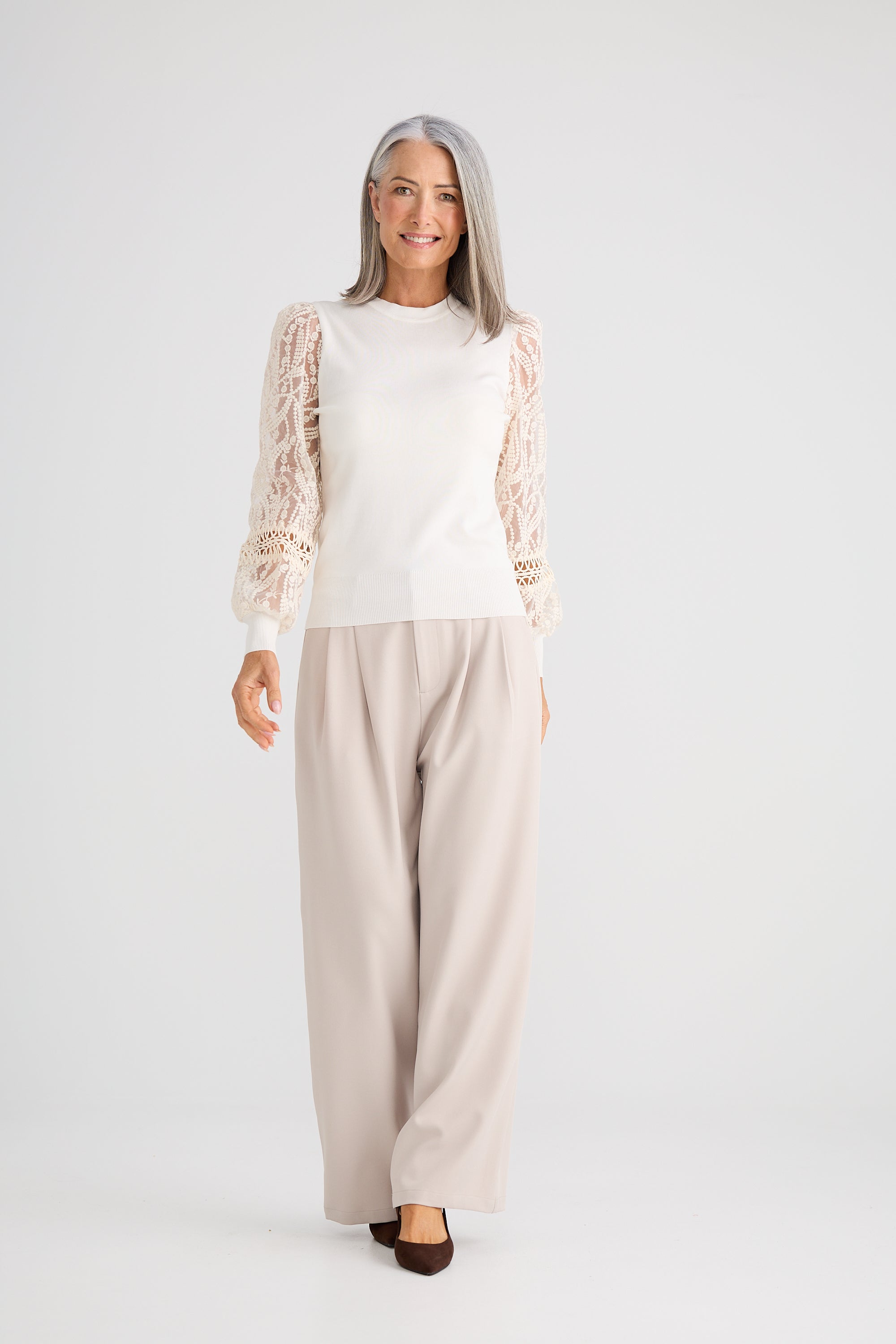 Collection of Woman wearing a Brave and True white top, beige cardigan, and beige pants on a white background in a gallery layout
