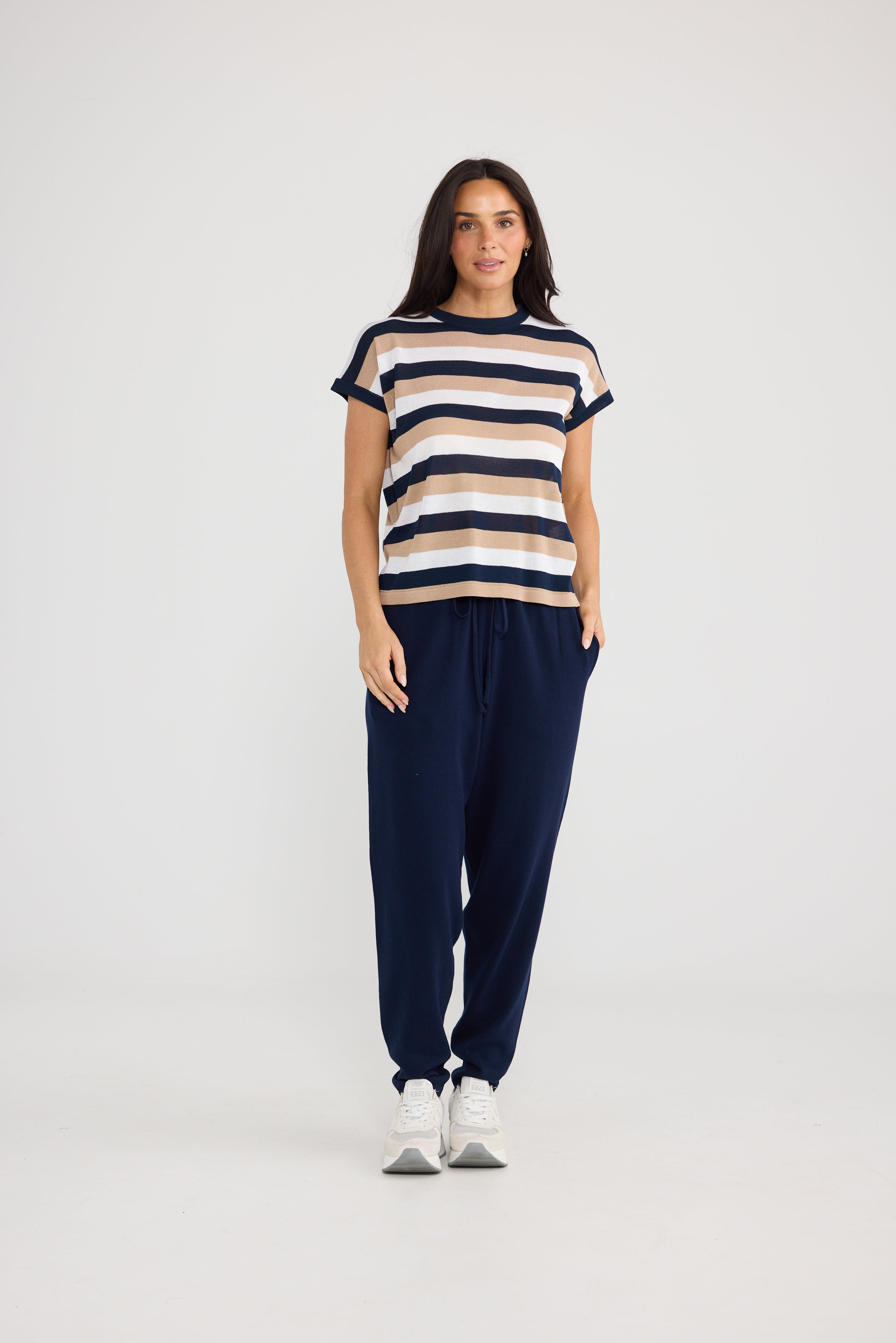 Image of Woman wearing a Brave & True beige Top and black pants on a white background
