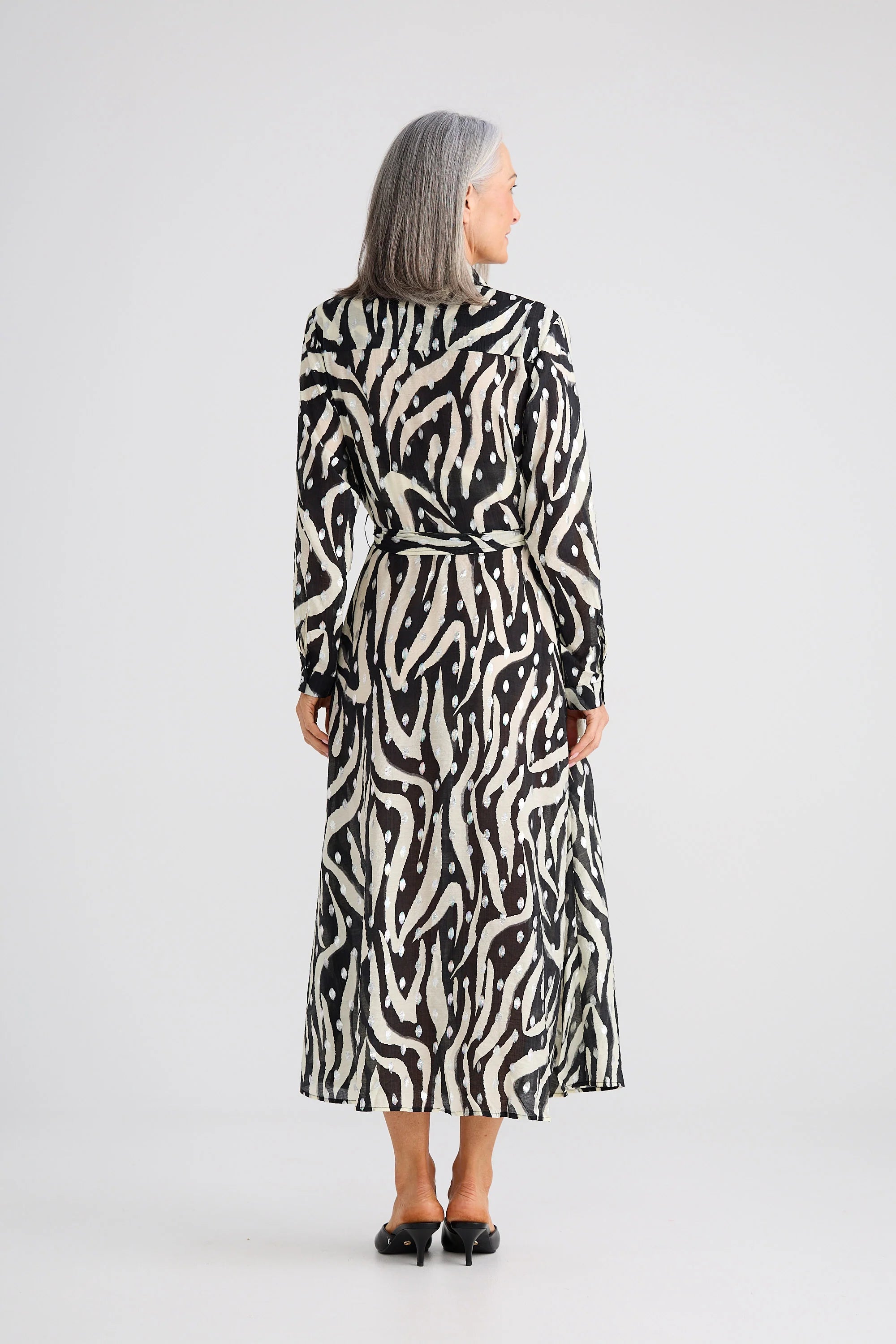 Image of Woman wearing a Brave and True black and white patterned dress on a white background