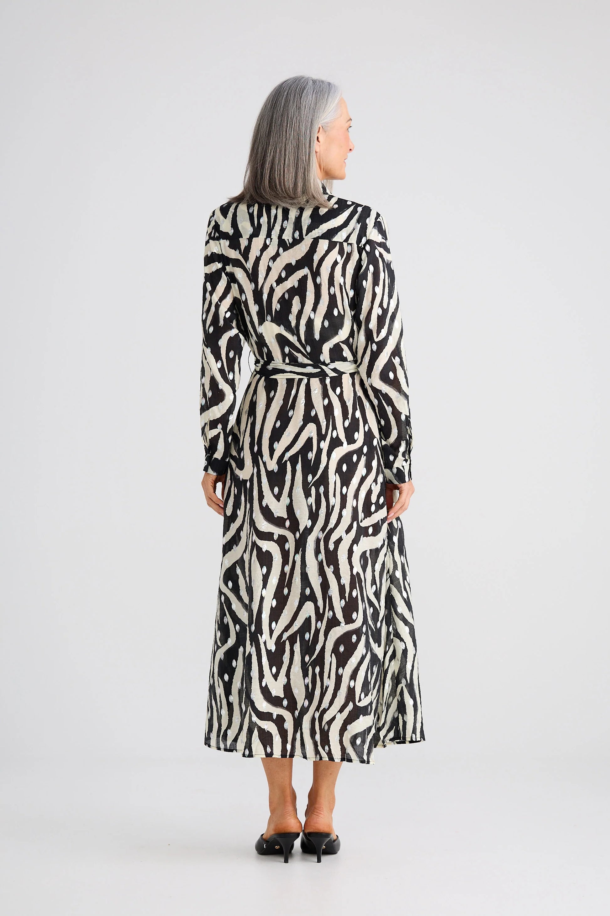 Woman wearing a Brave and True black and white patterned dress on a white background