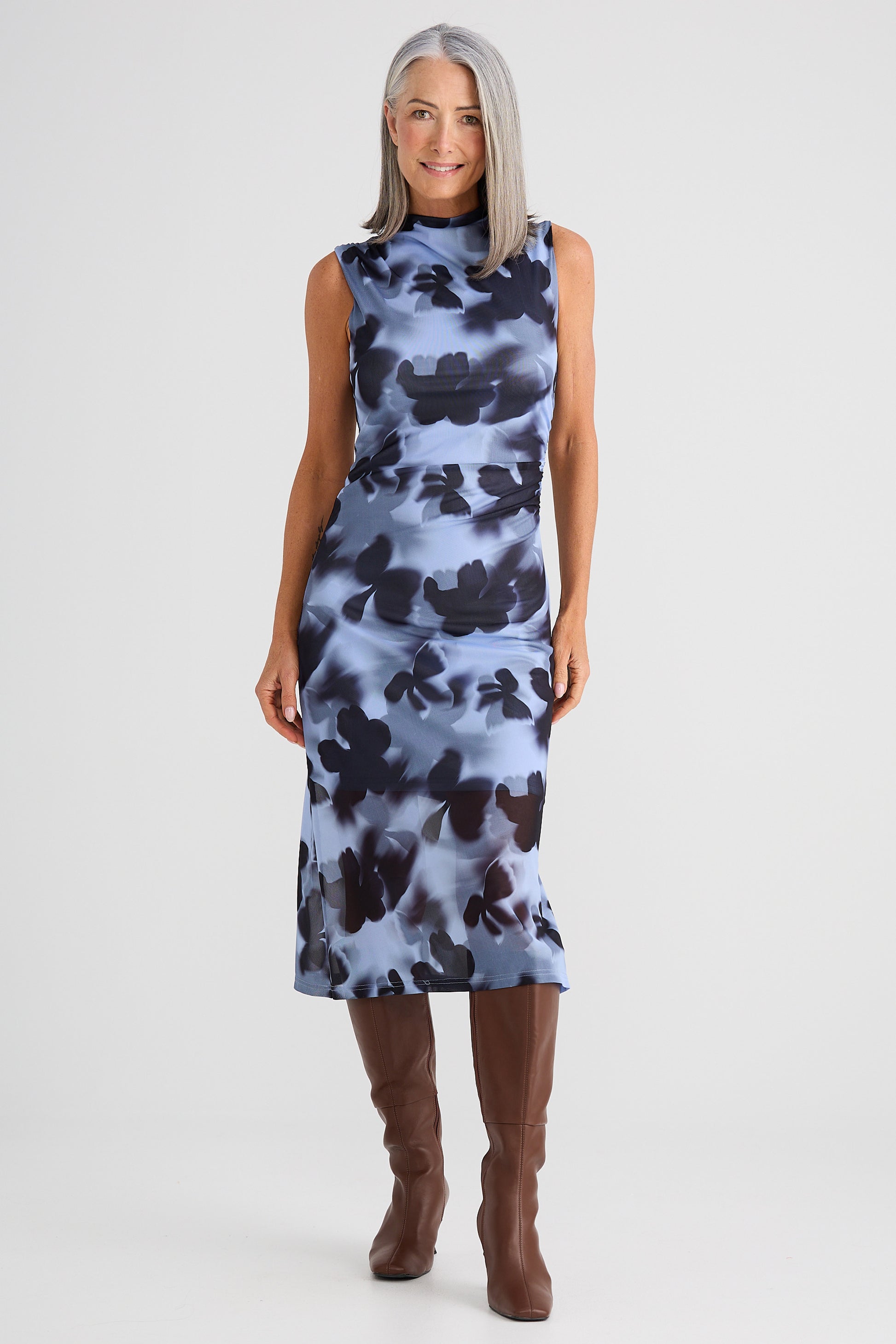 Woman wearing a Brave and True sleeveless dress with a floral pattern on a white background