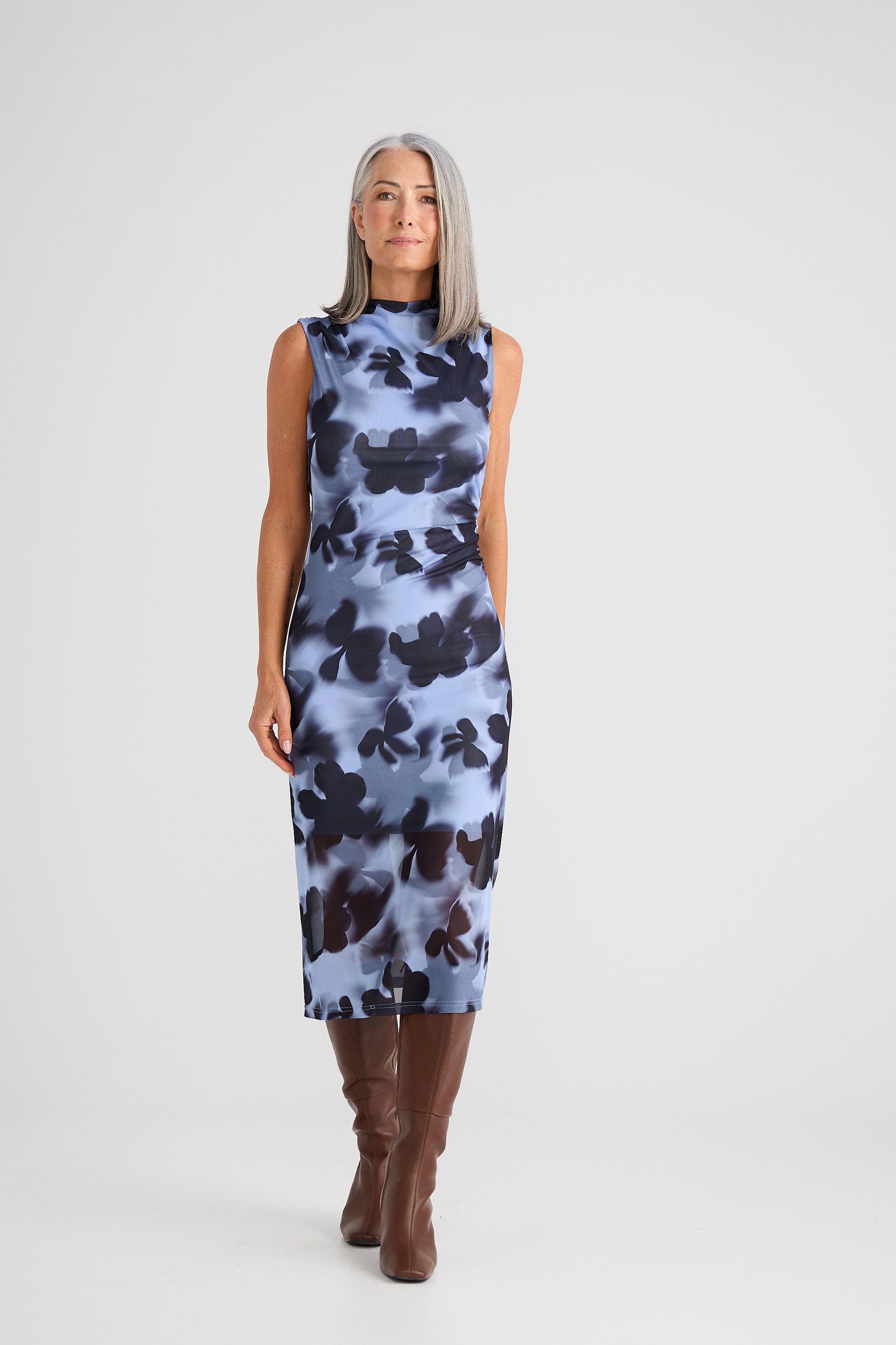 Woman wearing a Brave and True sleeveless dress with a floral pattern on a white background