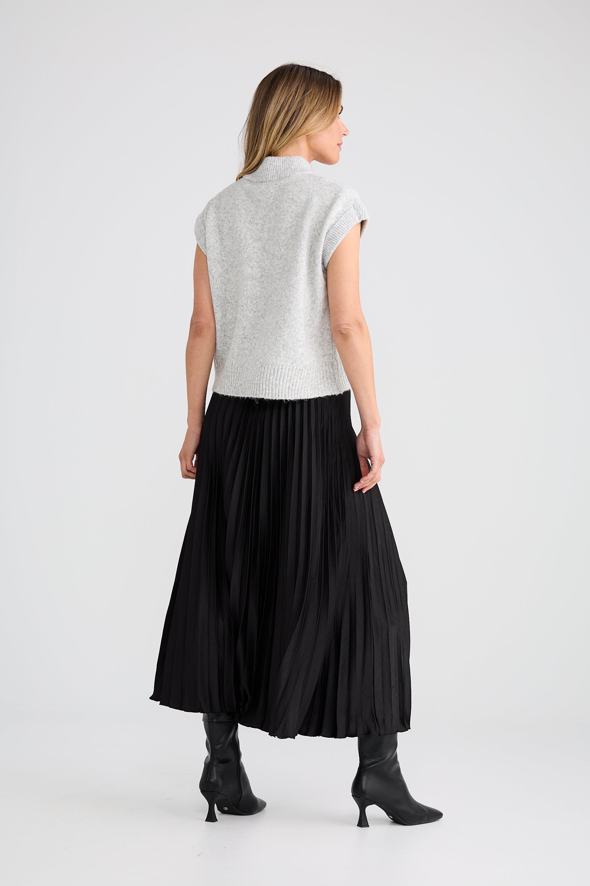 Image of Woman wearing a Brave and True light grey sleeveless top and black skirt on a white background