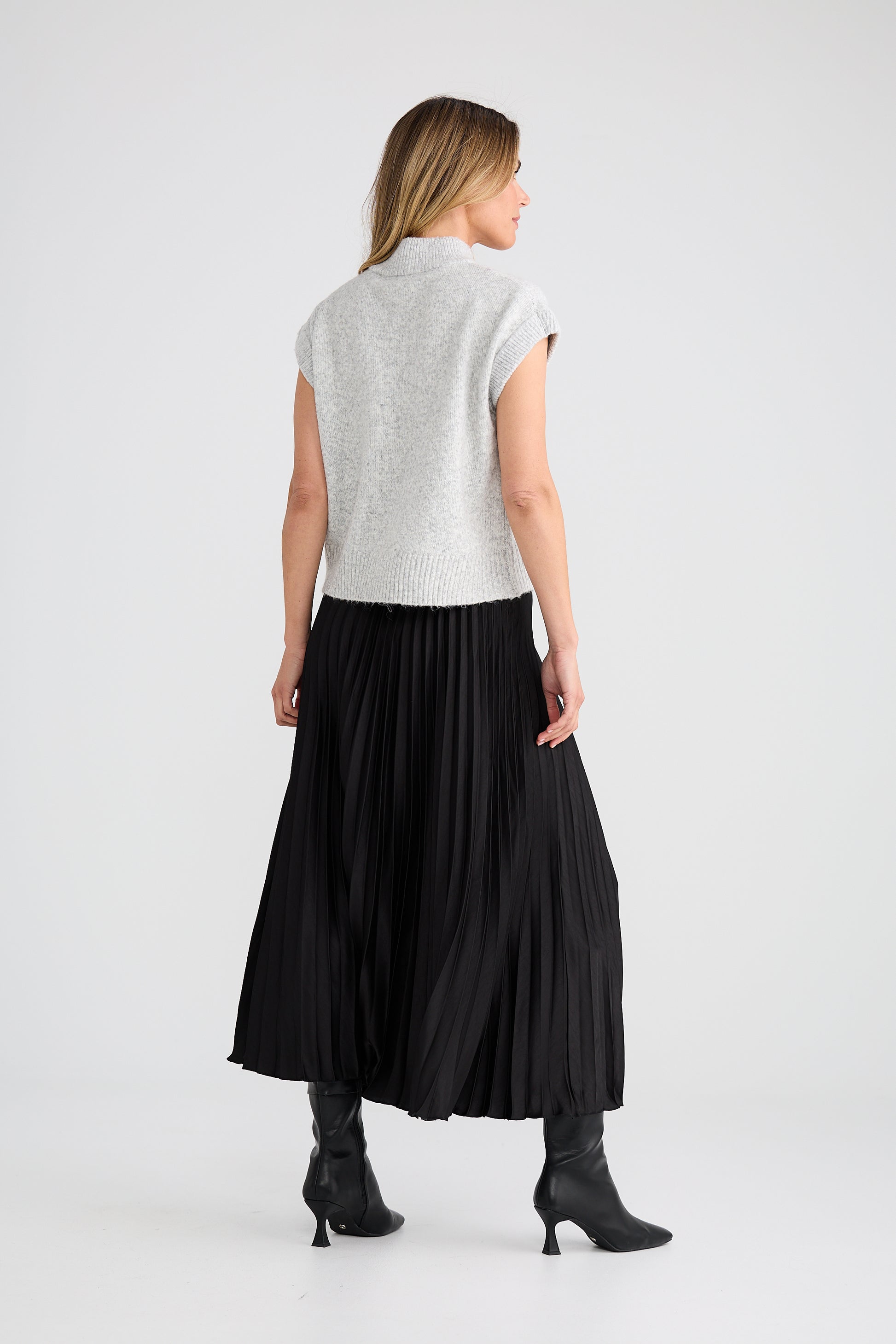 Woman wearing a Brave and True light grey sleeveless top and black skirt on a white background