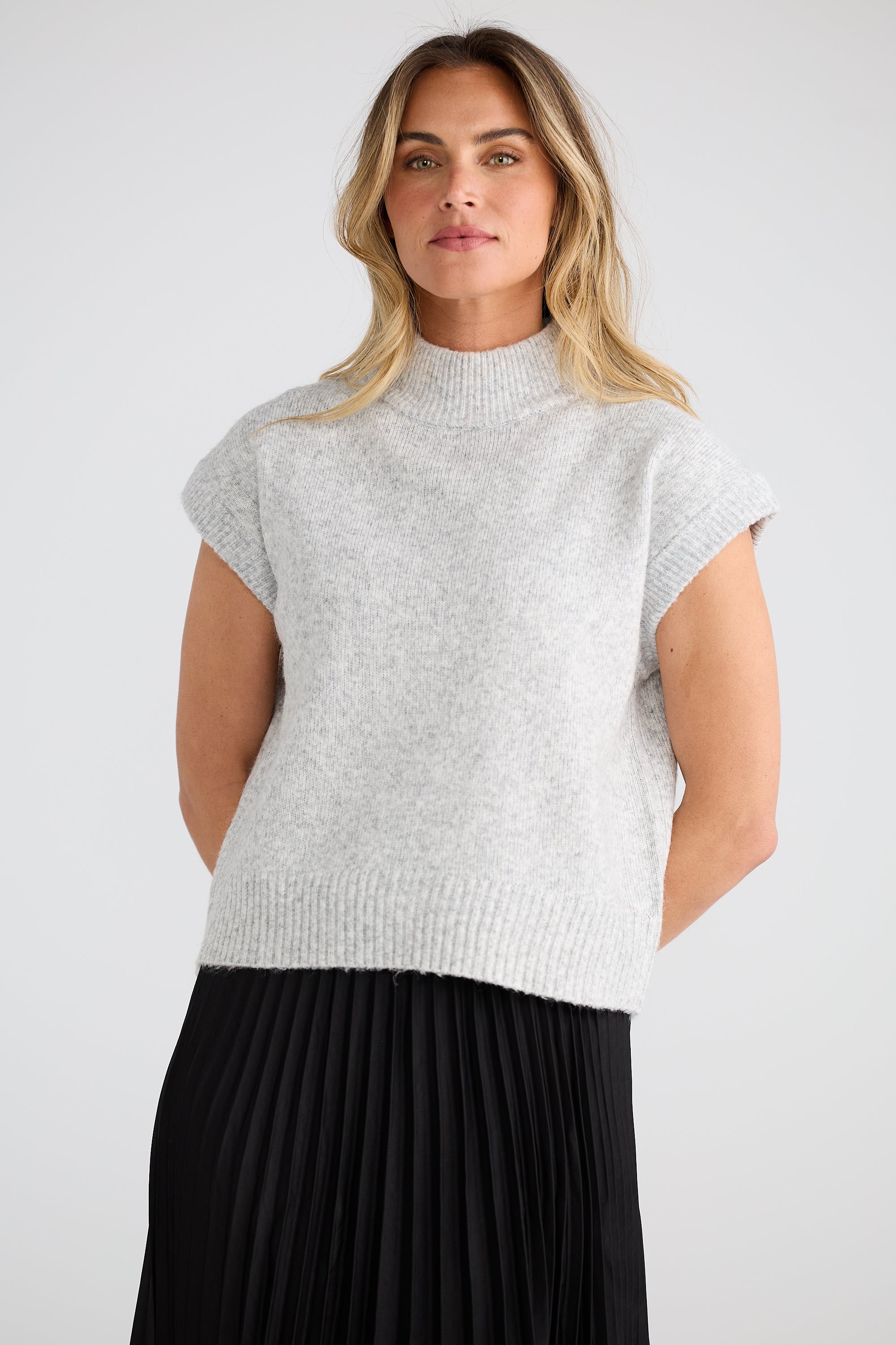 Image of Woman wearing a Brave and True light grey sleeveless sweater against a white background