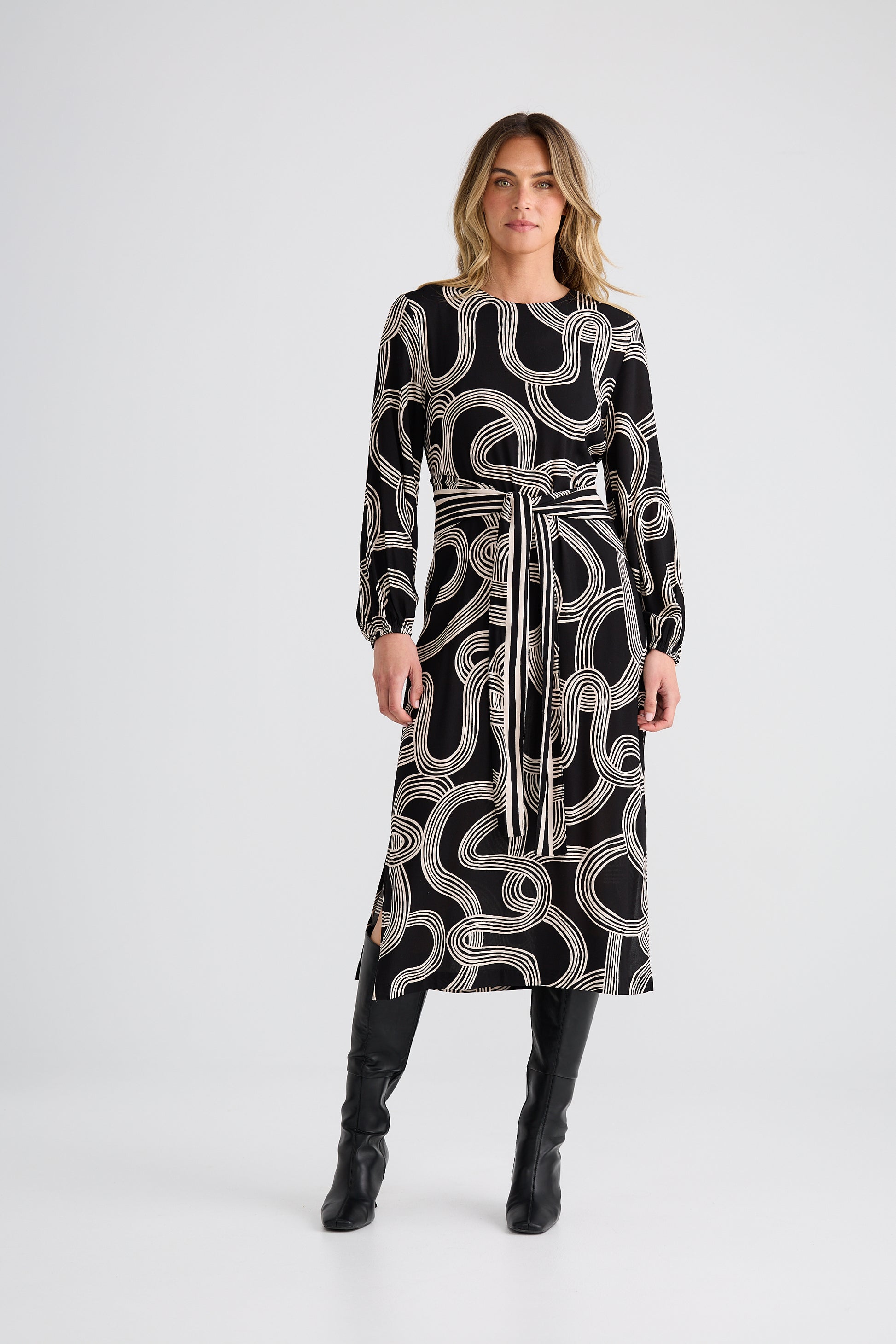 Woman wearing a Brave and True black dress with white pattern on a white background