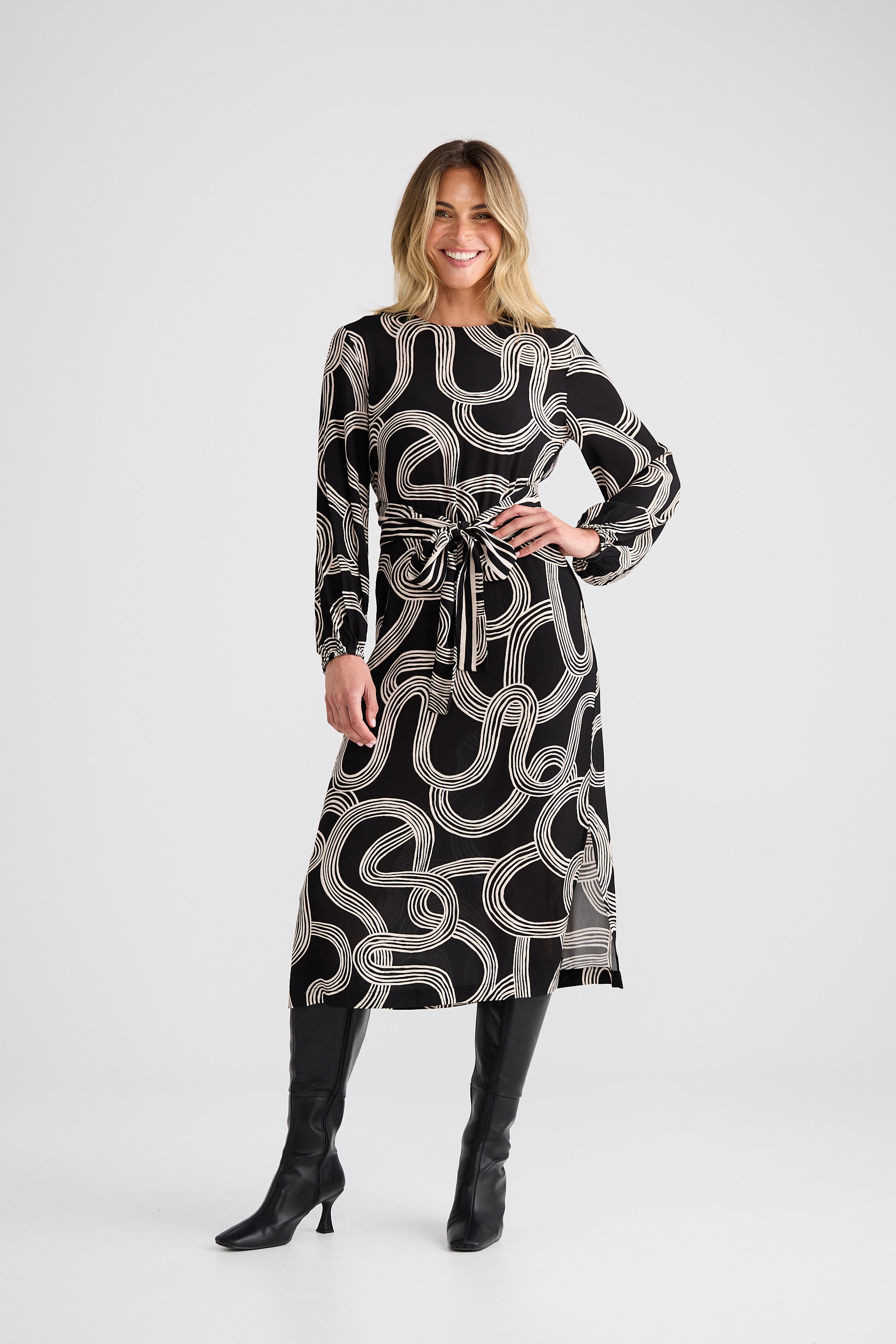 Woman wearing a Brave and True black and white patterned dress with long sleeves on a white background