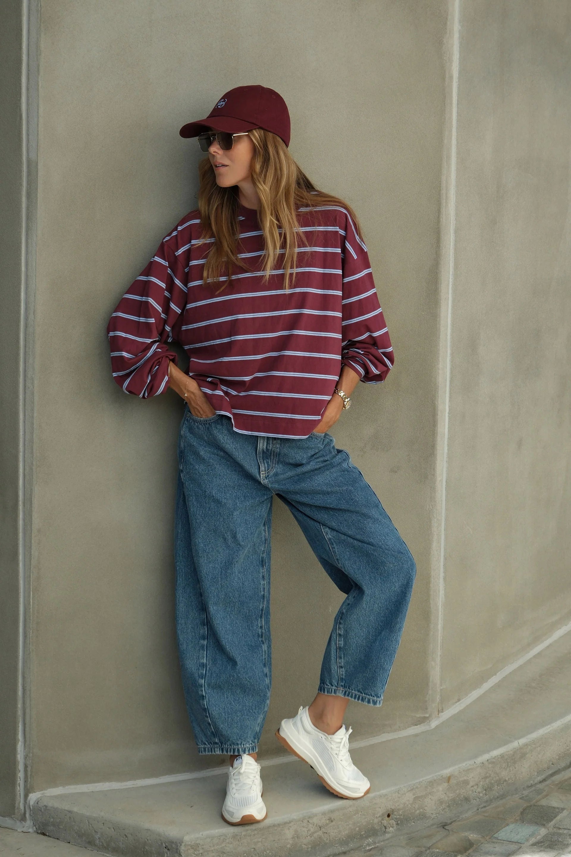 Image of Woman wearing Ceres Life long sleeve burgundy and navy stripe paired with denim jeans and sneakers 
