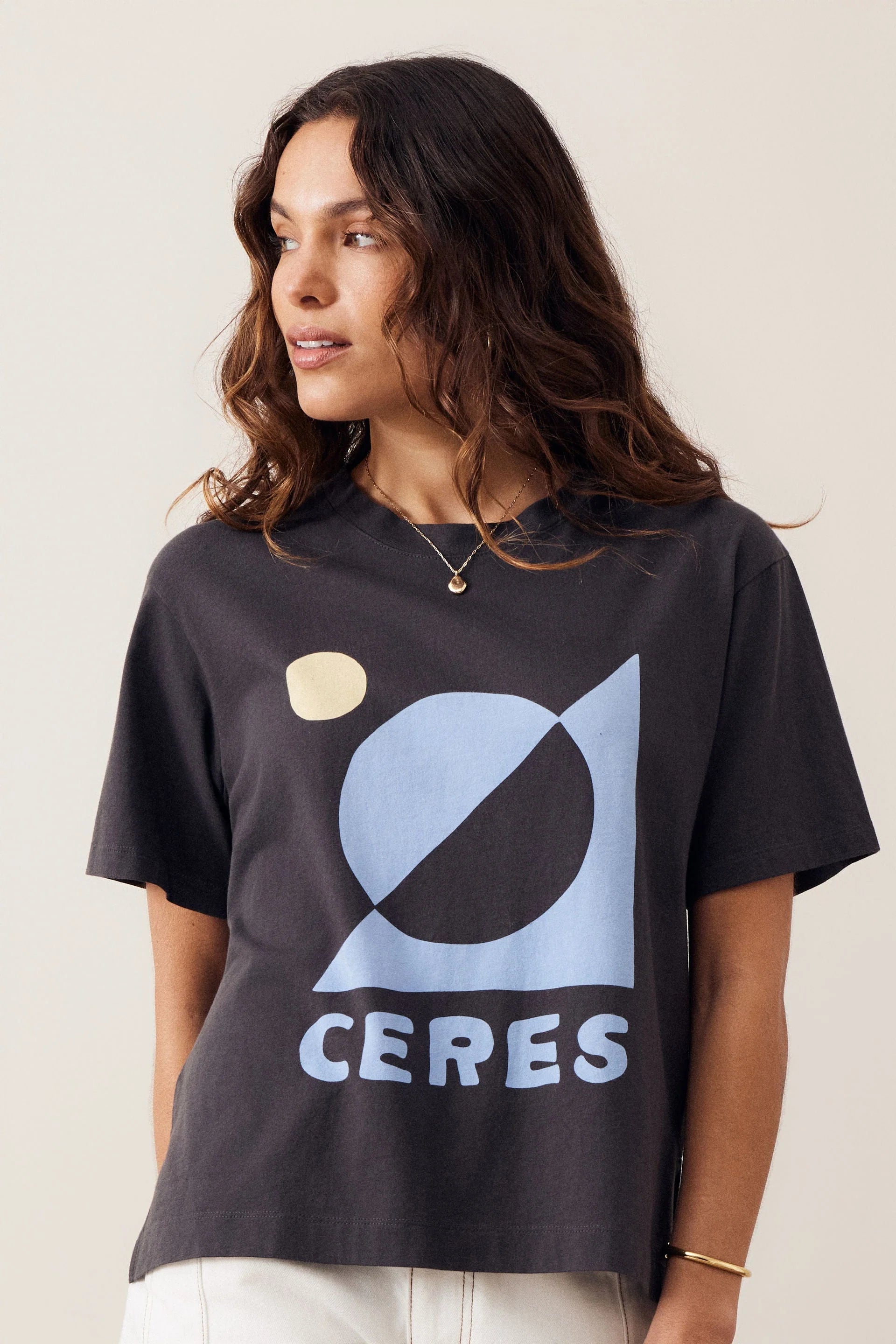Image of Woman wearing a Ceres graphic tshirt paired with a plain pair of white jeans on a plain background