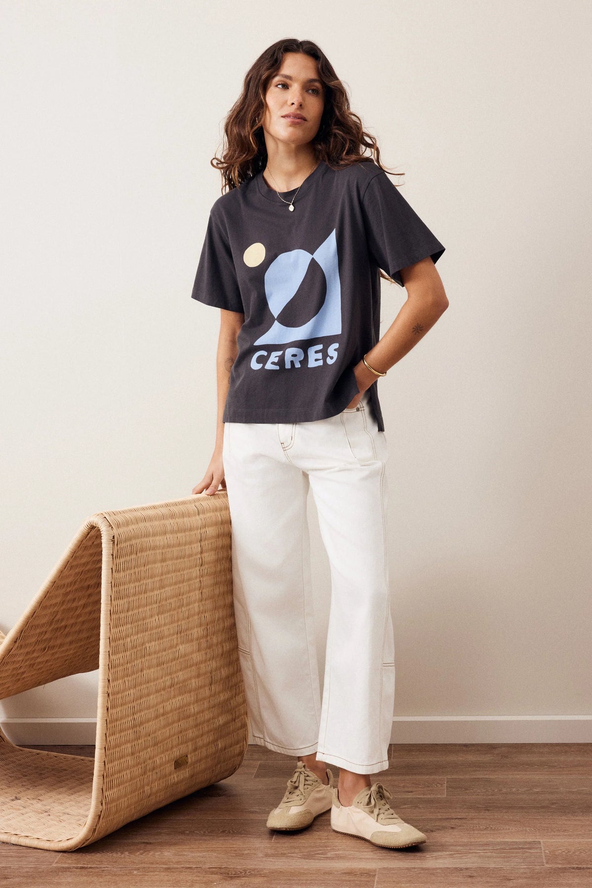Woman wearing a Ceres graphic tshirt paired with a plain pair of white jeans on a plain background