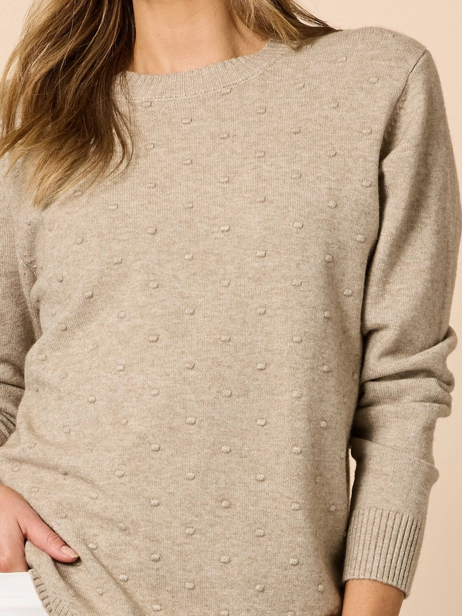 Image of Clarity Beige sweater with textured pattern worn by a person