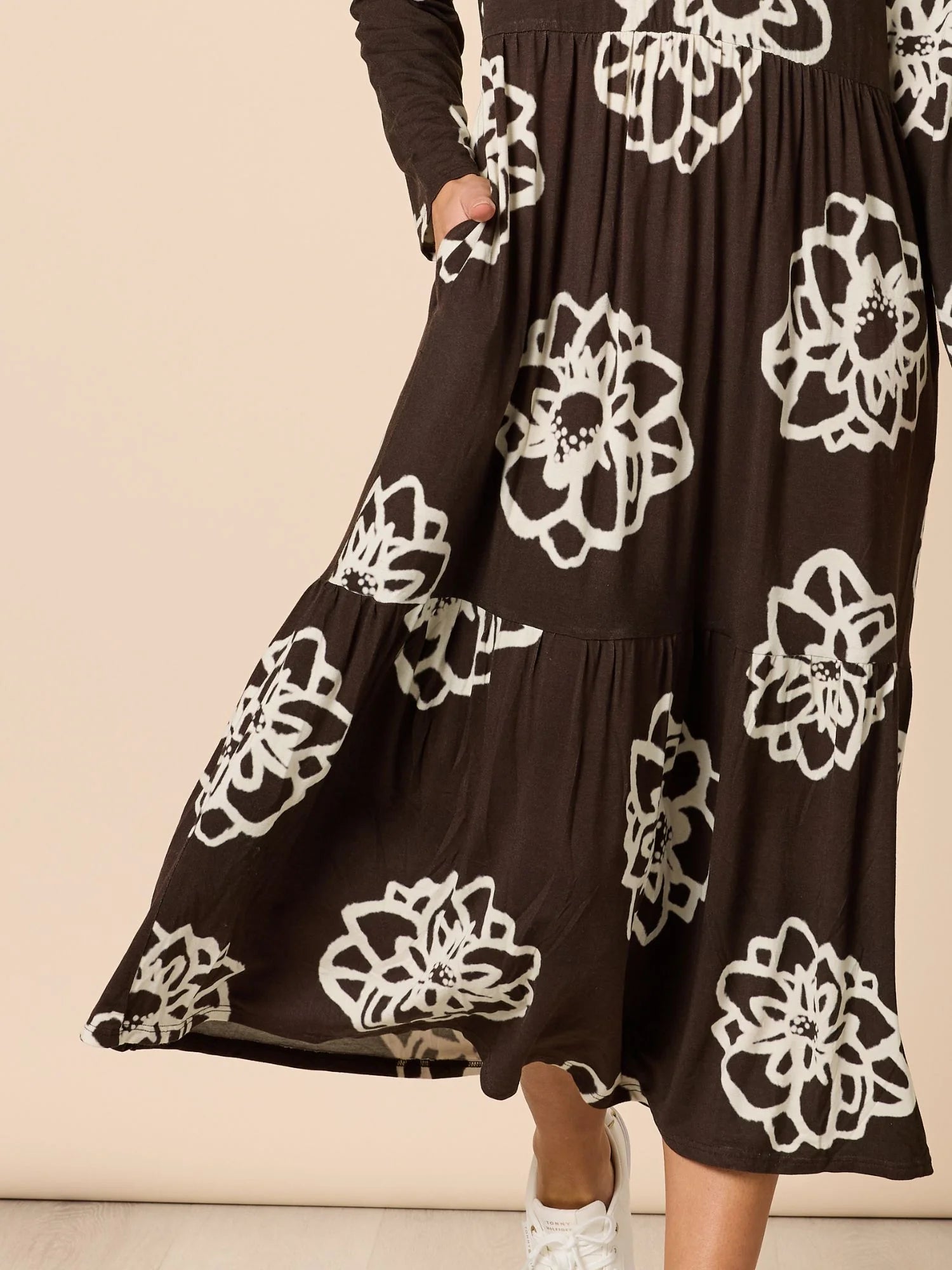 Image of Clarity Brown dress with white floral patterns on a beige background