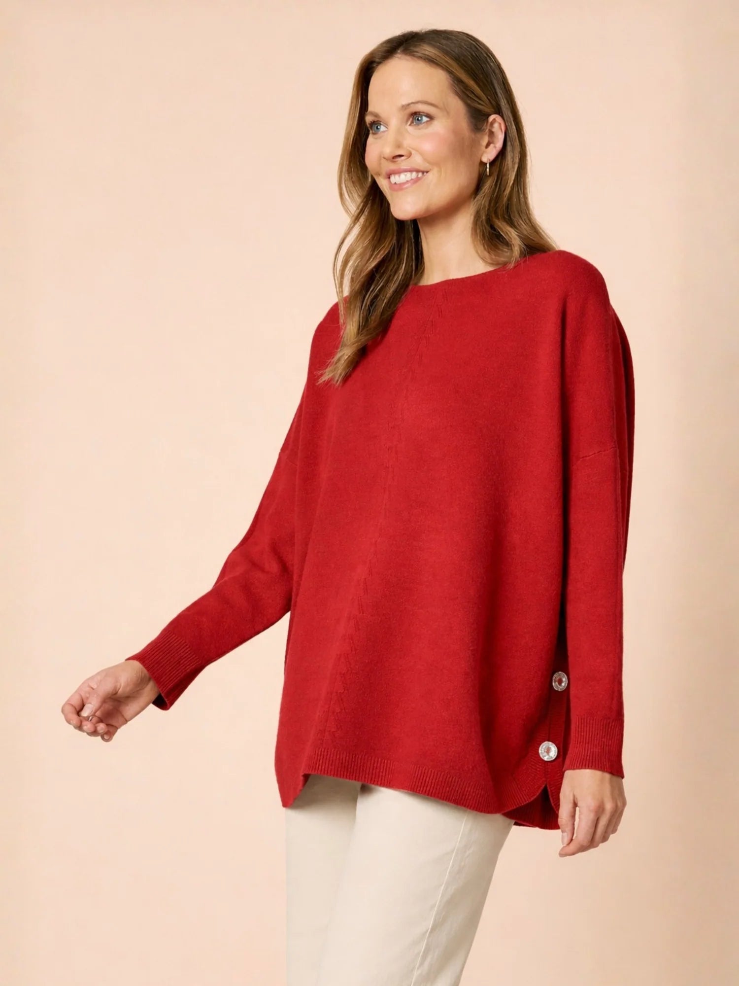 Woman wearing a Clarity red sweater with button details on a beige background