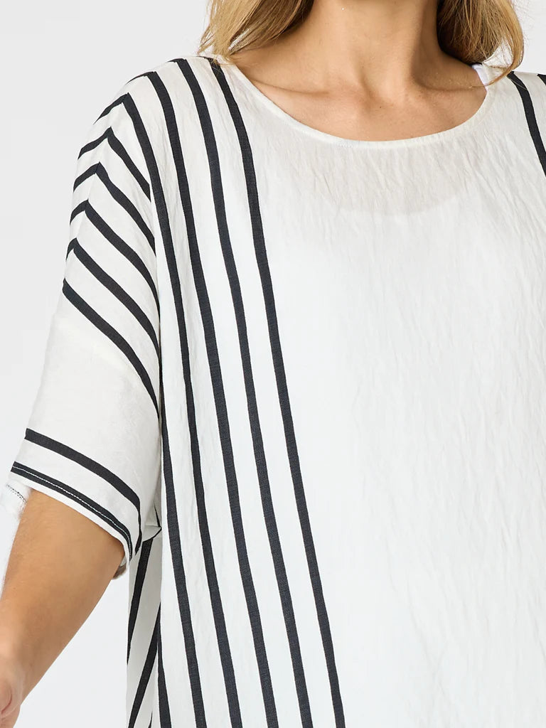 Image of A close-up of a woman wearing a Clarity white short-sleeve top with vertical black stripes on one side and a solid white panel on the other.