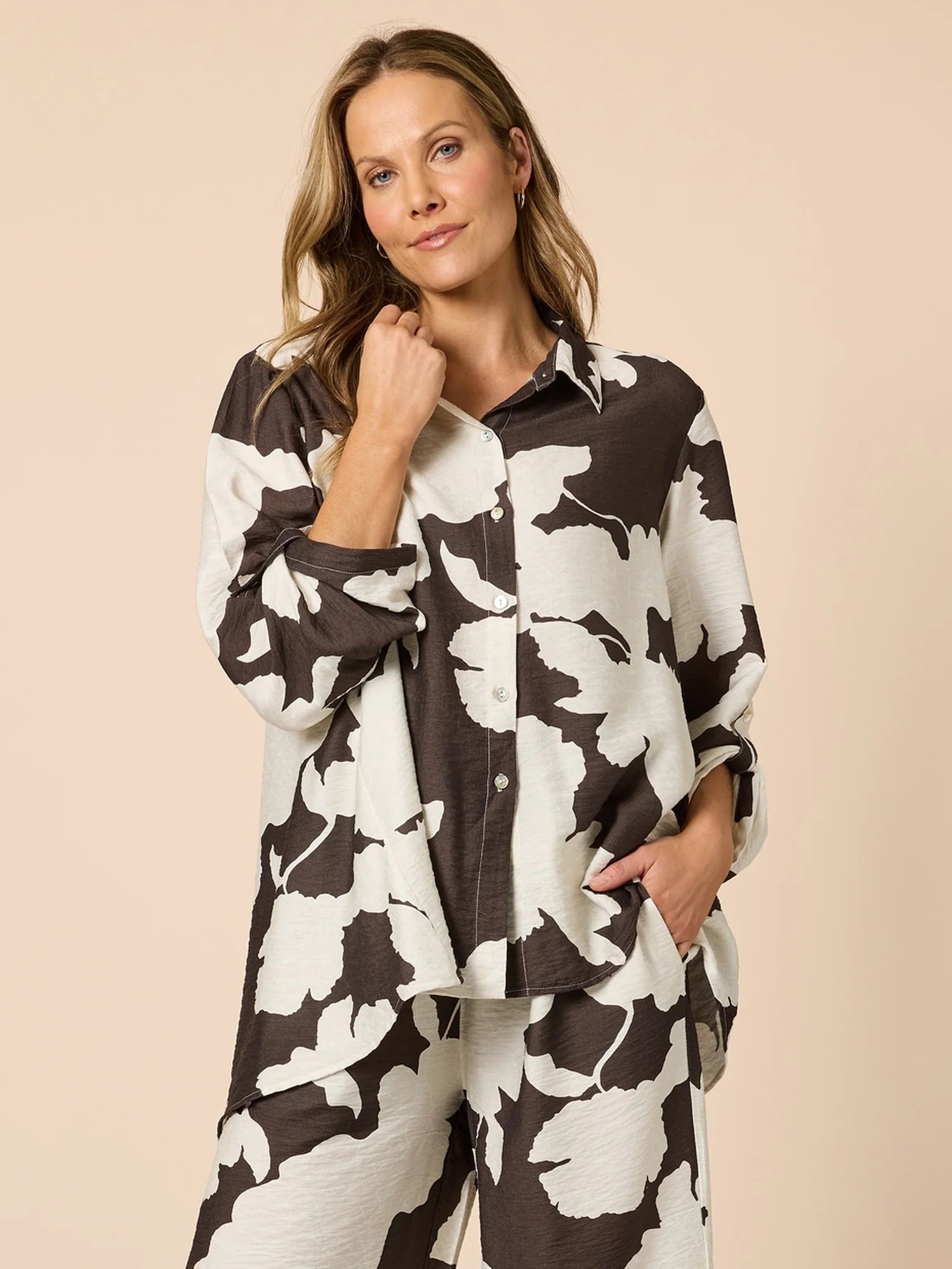 Image of Woman wearing a Clarity black and white floral patterned shirt on a beige background