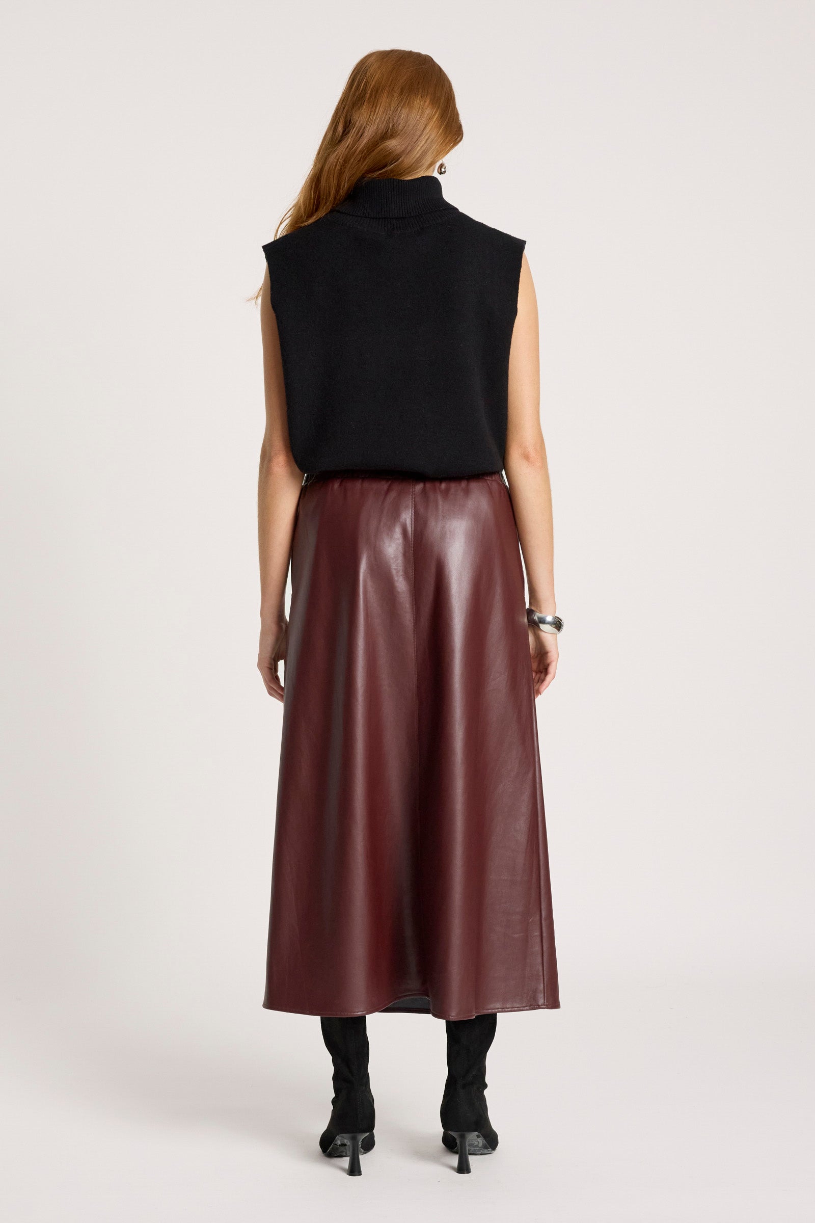 Image of Person wearing a black sleeveless top and Eb & Ive brown leather skirt on a white background