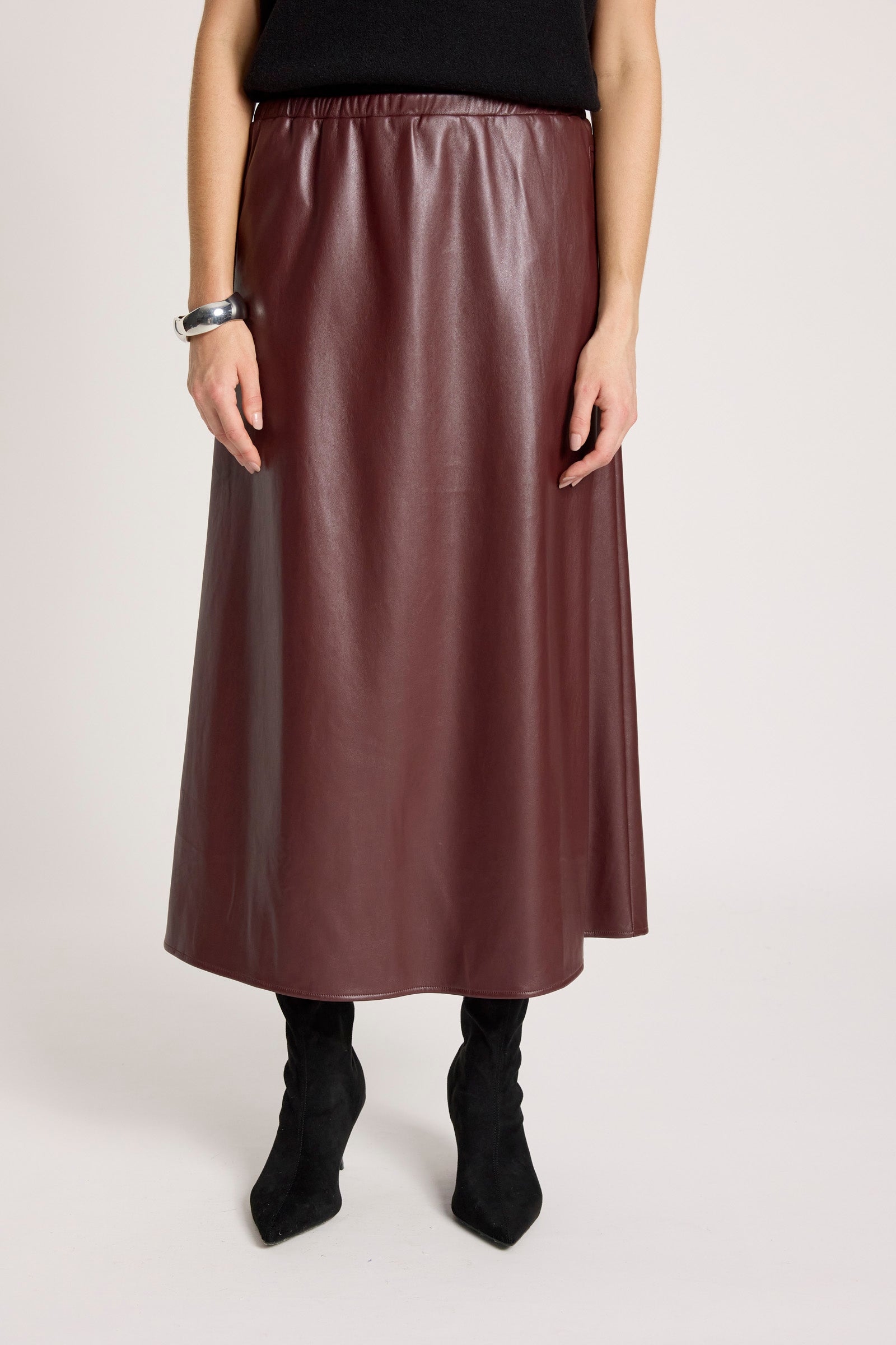 Woman wearing a Eb & Ive brown leather skirt on a plain background 