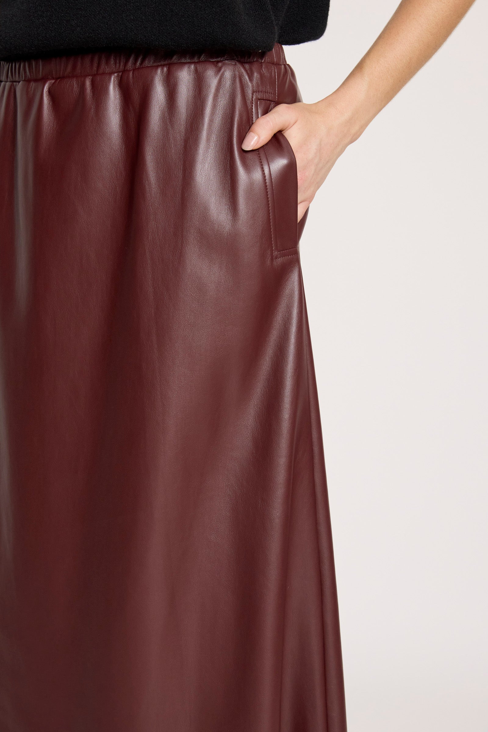 Woman wearing Eb & Ive Brown leather skirt worn by a person on a light gray background