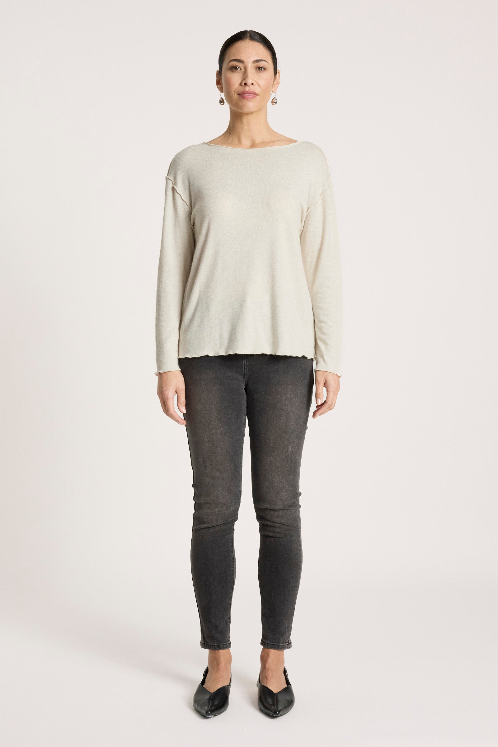 Image of Woman wearing a Eb & Ive beige long-sleeve top and dark gray pants on a white background